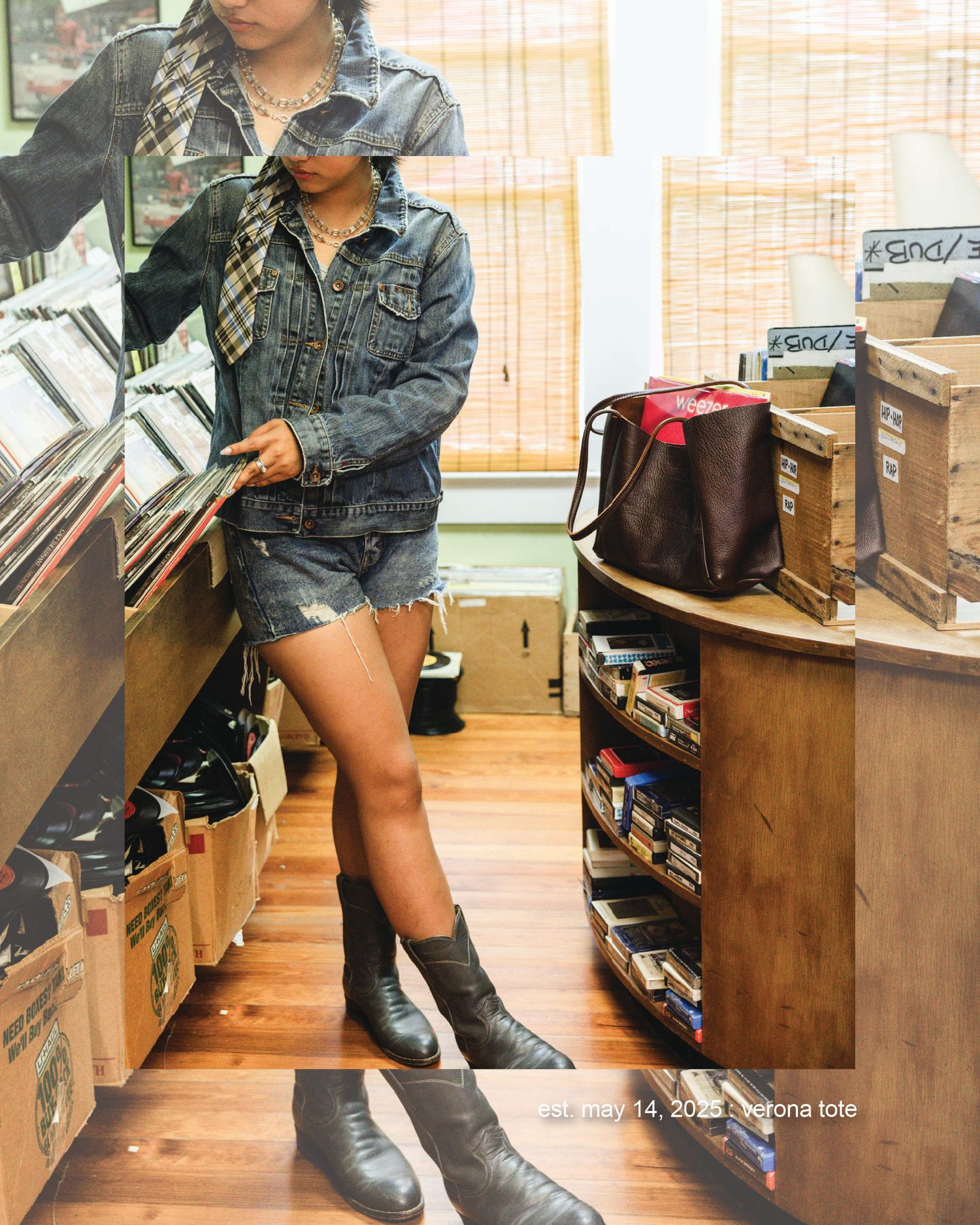 Woman in denim jacket, shorts, and black boots browsing vinyl records in a music store.