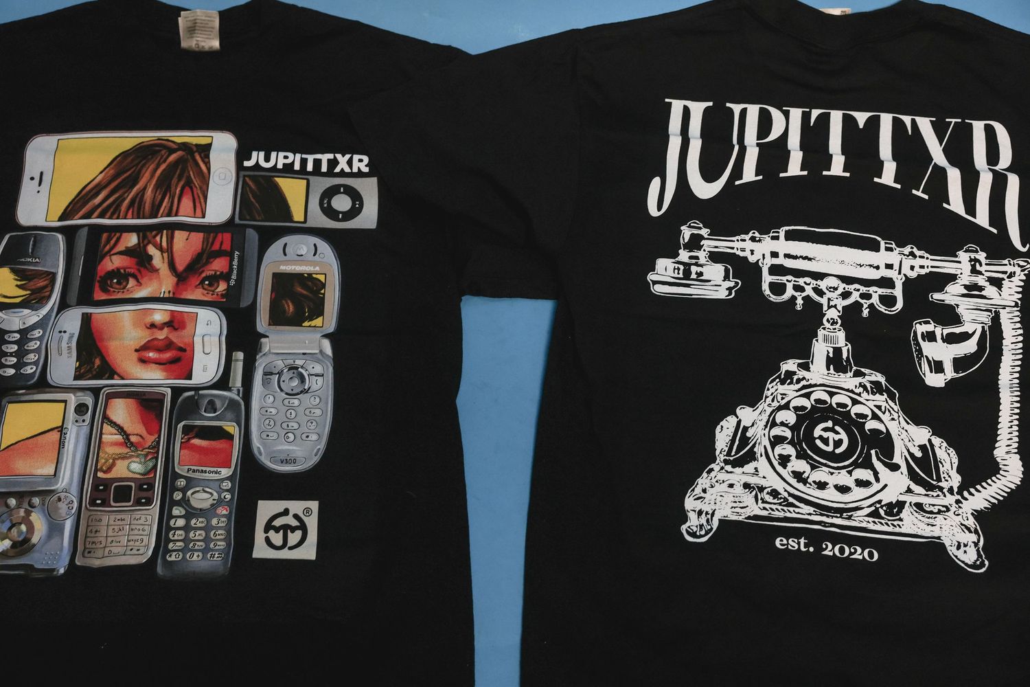 Two black JUPITTXR t-shirts displayed showing front graphic and back telephone logo designs.