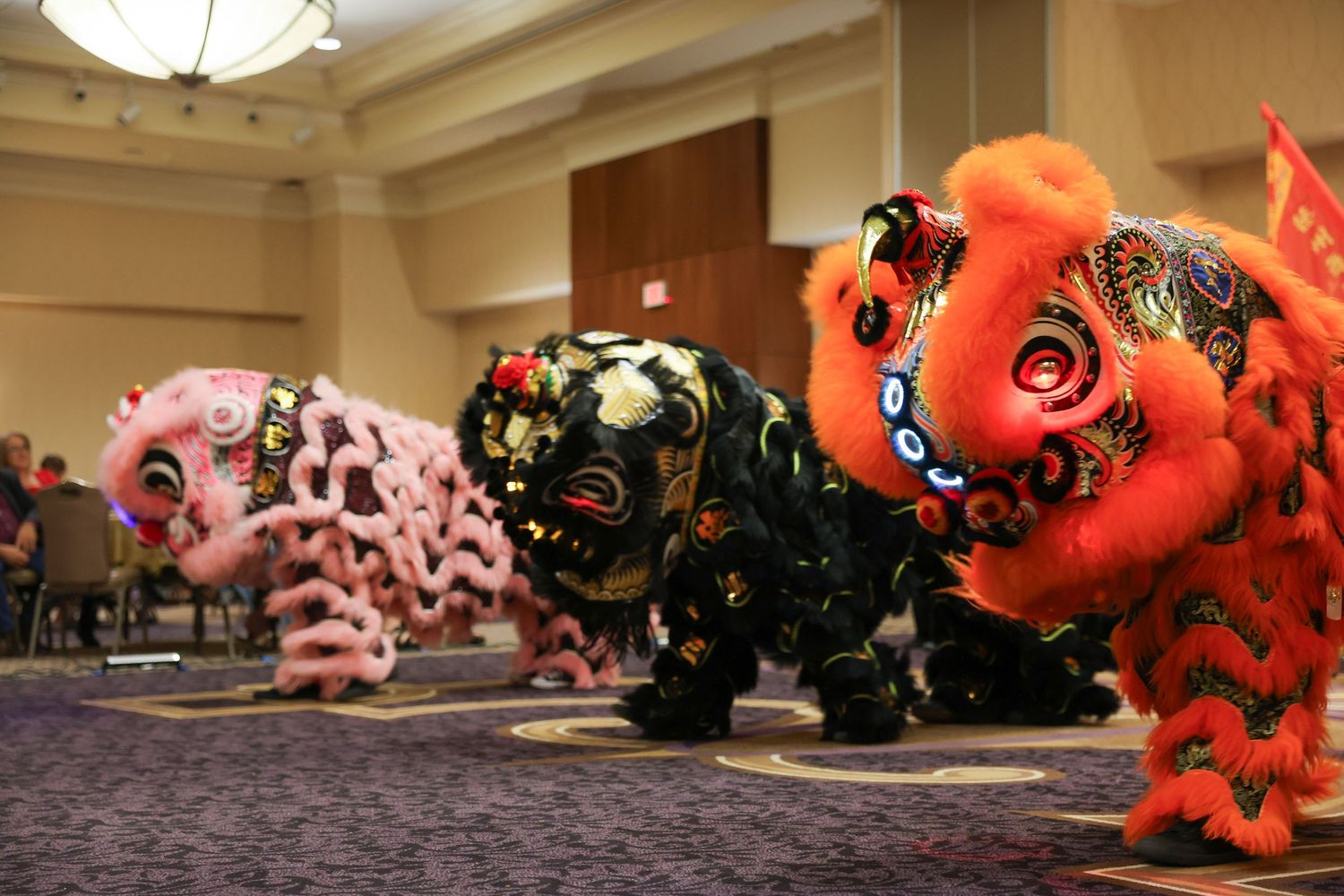 Three vibrant lion dance costumes resting on floor during Chinese New Year celebration performance.