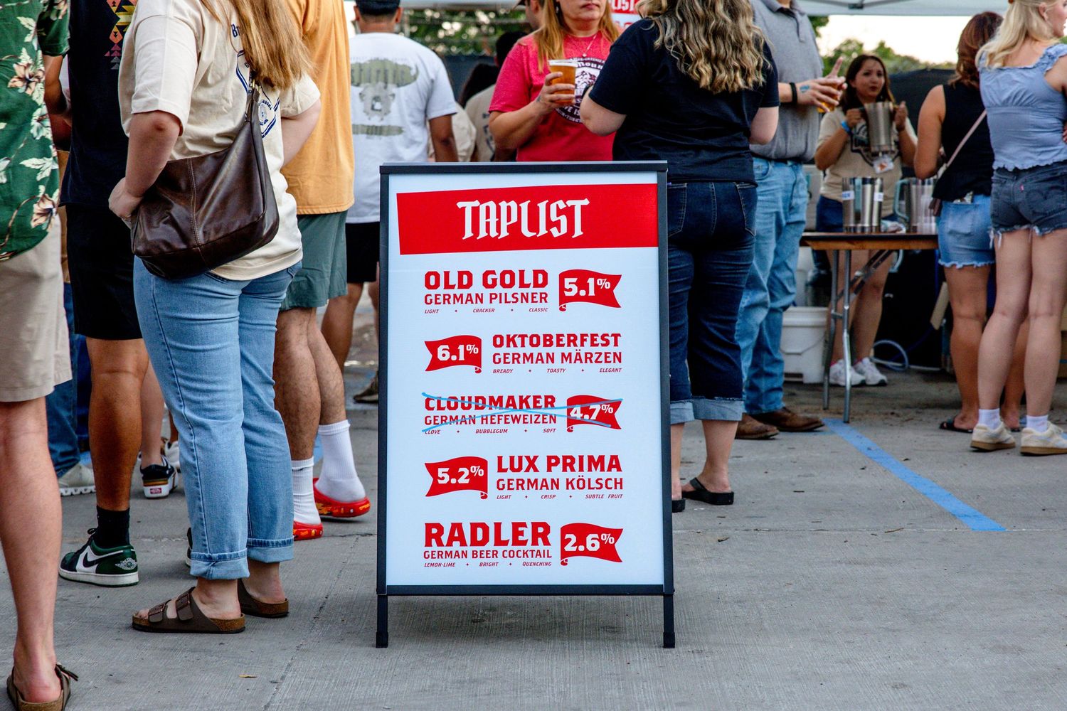 Outdoor tap list sign featuring German-style beers including Oktoberfest and Radler options.