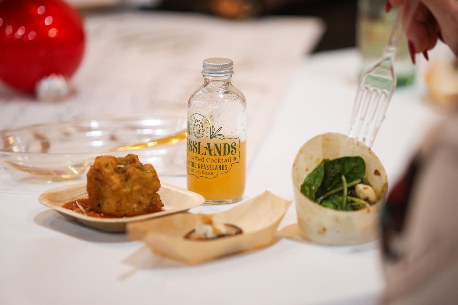 Plate of fried food with dipping sauce and a small Grasslands beverage bottle.