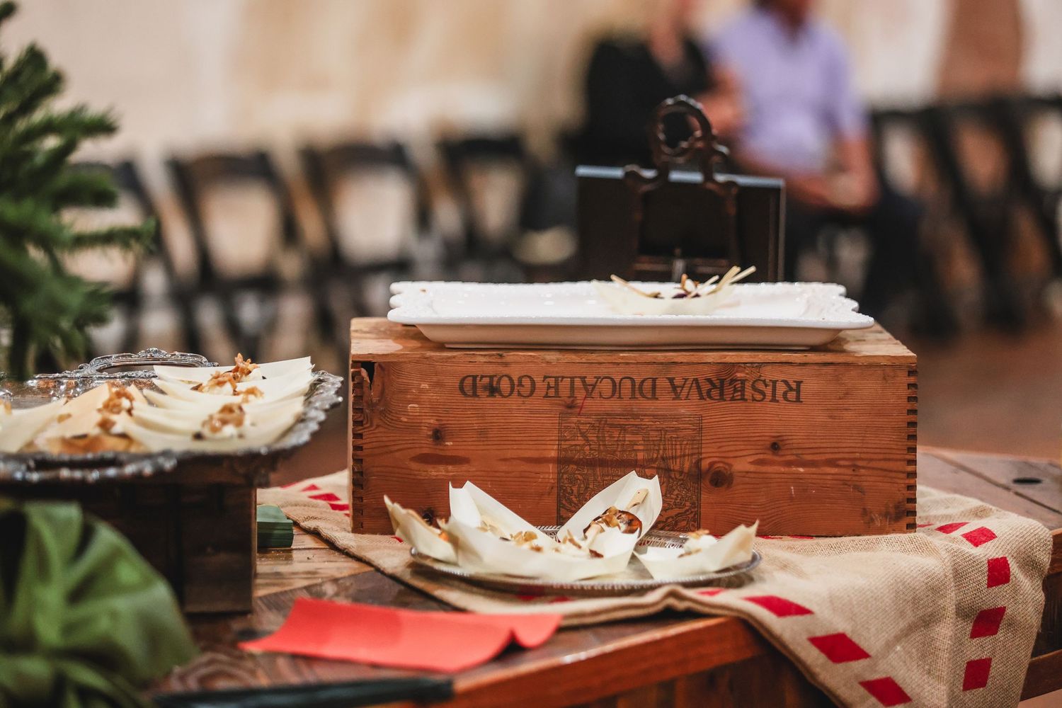 Rustic wooden wine crate centerpiece with menus on a burlap-covered table at an elegant event.