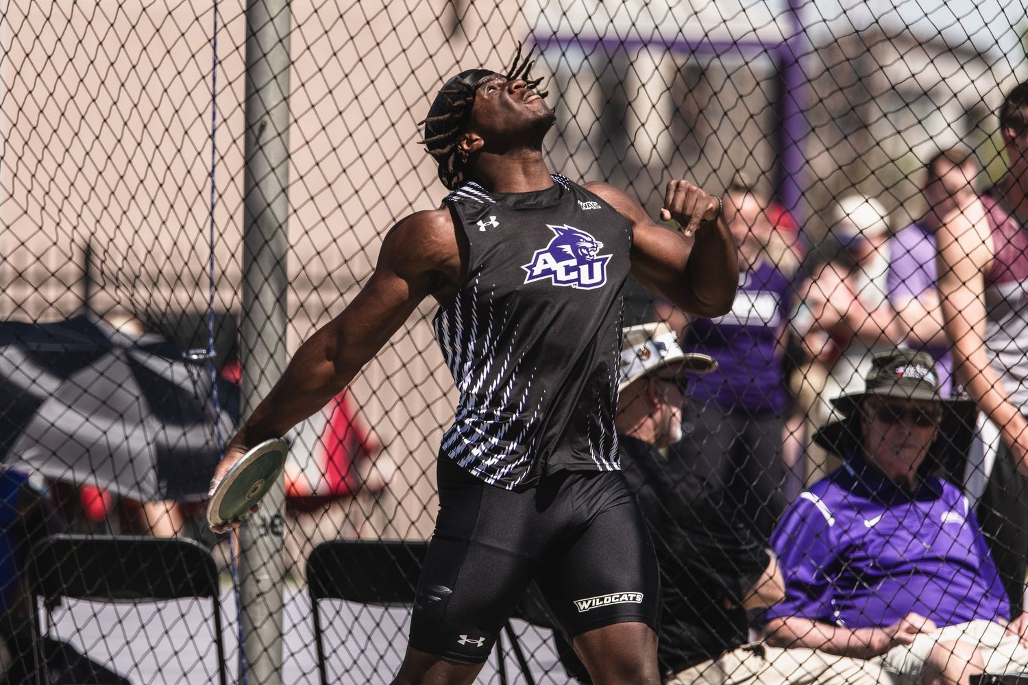 ACU athlete competes in discus throw event during outdoor track and field competition.