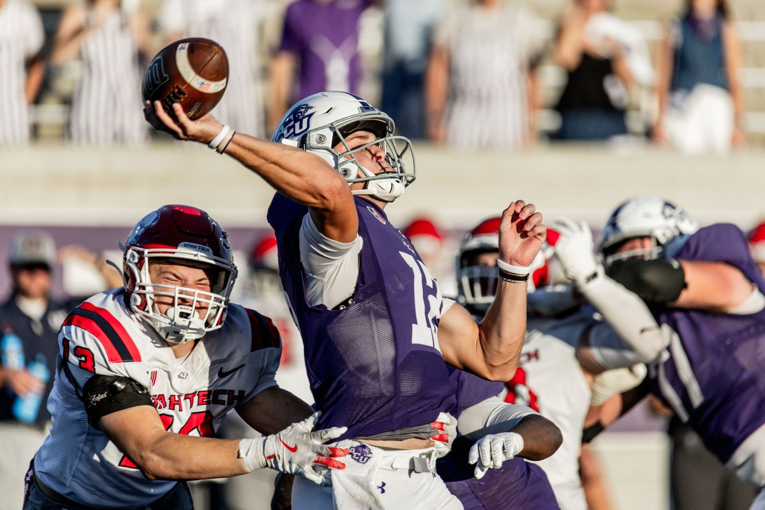 ACU quarterback throws a pass under pressure during a college football game.