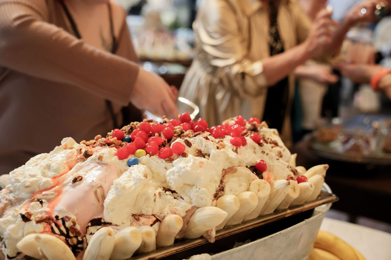 Elegant dessert tray topped with whipped cream, raspberries, and chocolate at a catered social event.