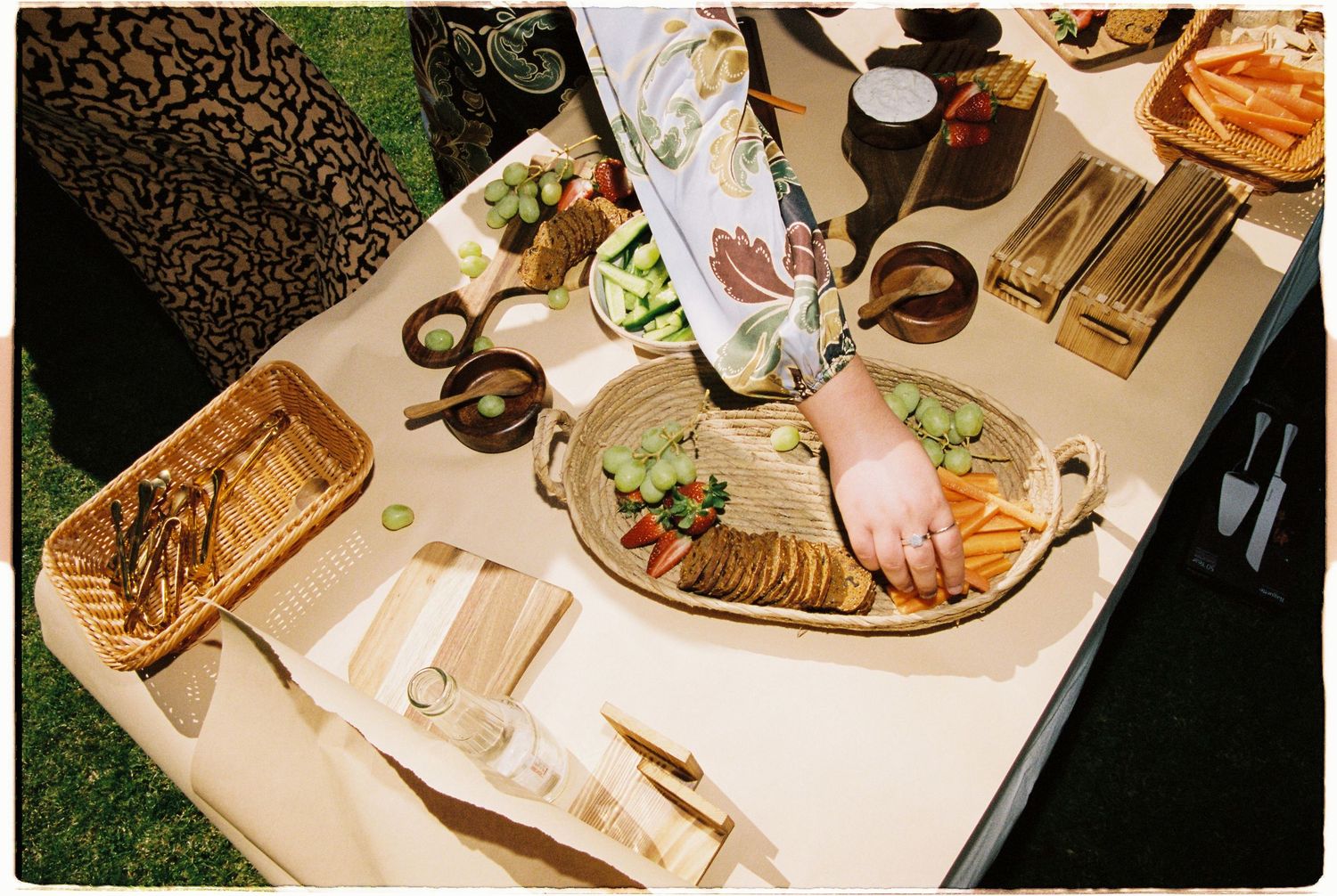 Overhead view of a wedding grazing table with crackers, vegetables, and assorted appetizers.