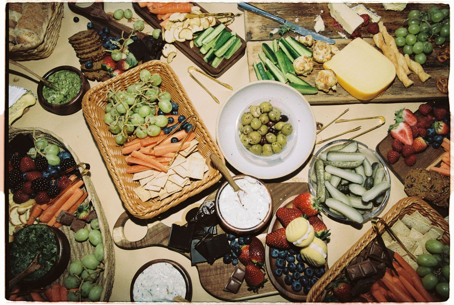 Overhead view of an elaborate wedding grazing board with fruits, vegetables, and cheeses.
