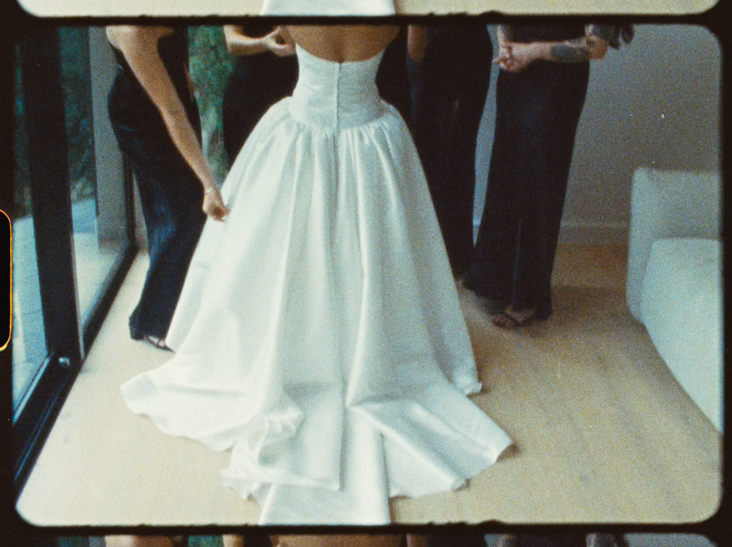 Close-up back view of a bride in a structured white strapless wedding gown with a full skirt.