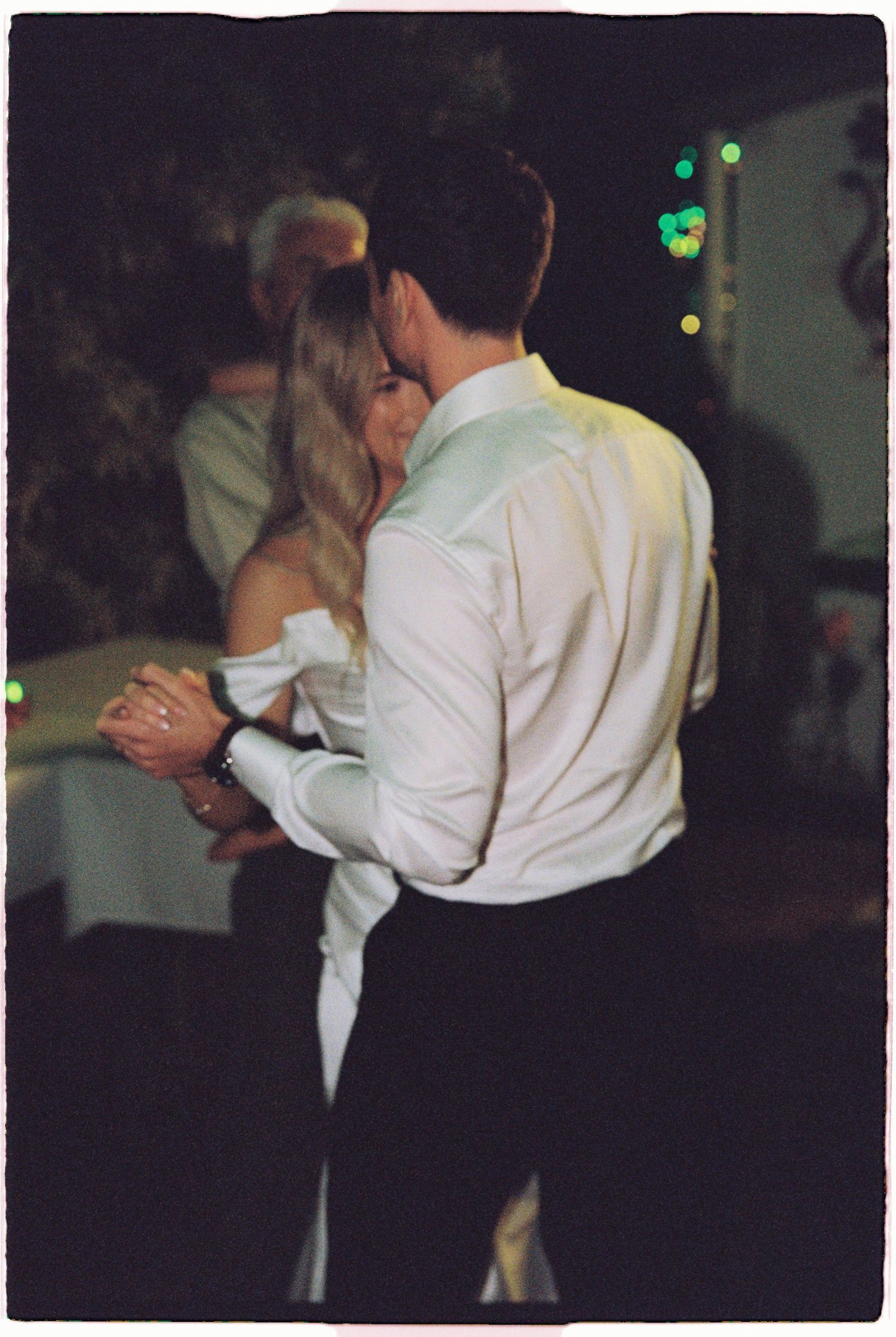 Bride and groom share an intimate first dance embrace at their wedding reception.