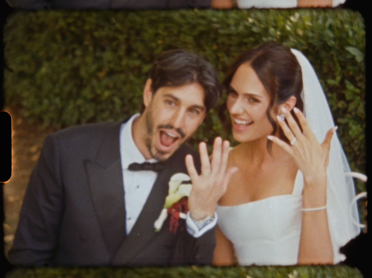 Happy newlyweds display their wedding rings with big smiles in a classic post-ceremony portrait.