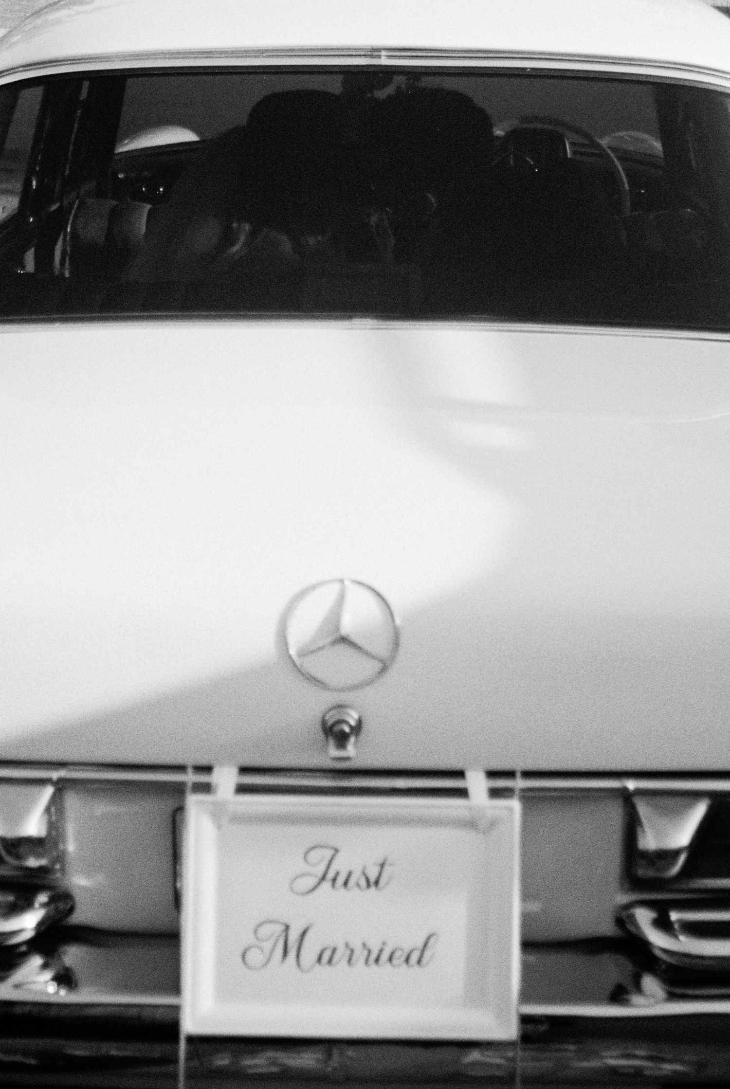 Classic vintage Mercedes-Benz wedding car with Just Married sign in black and white.