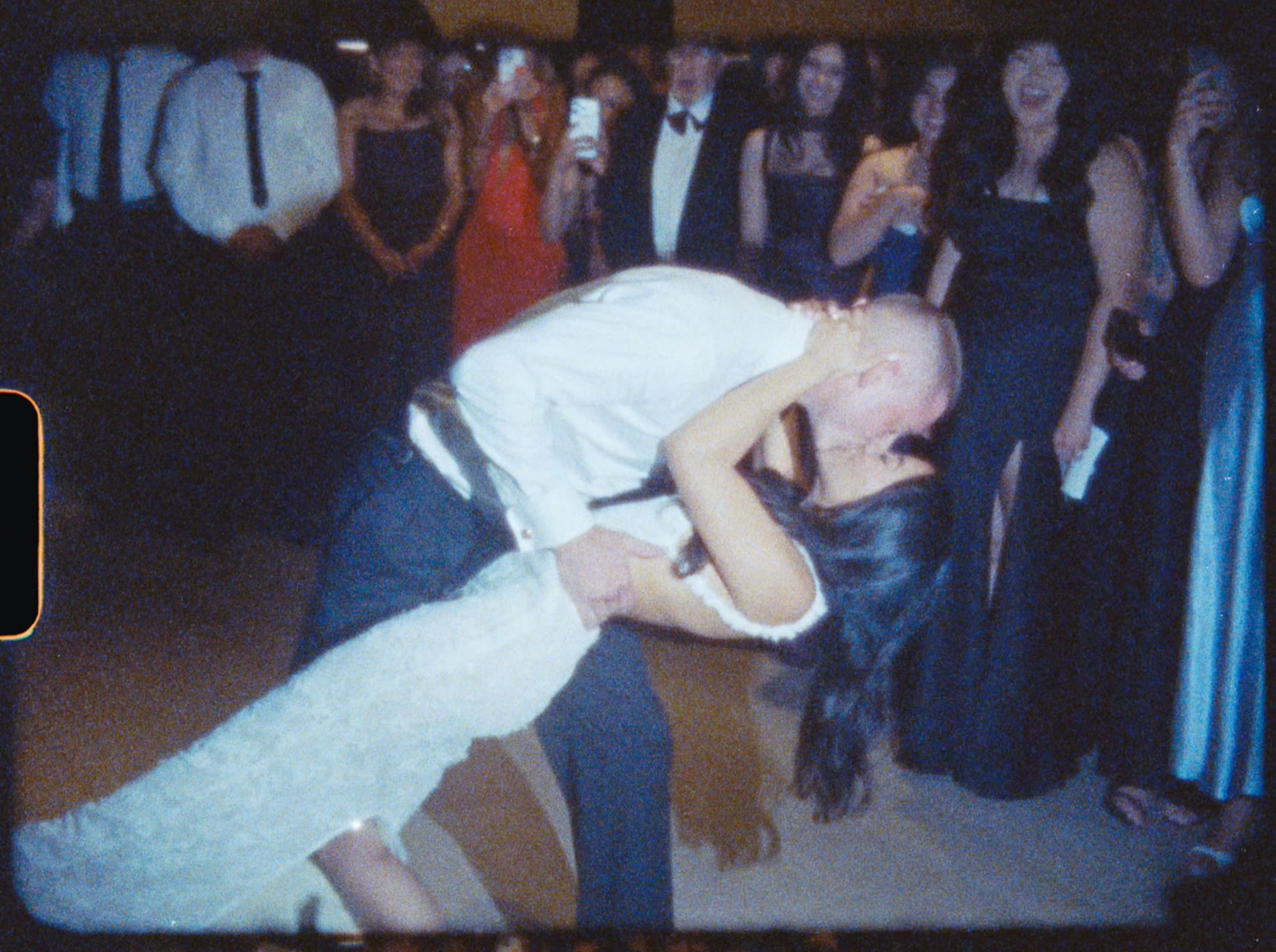 Bride and groom share a dramatic dip kiss on the dance floor at their wedding reception.