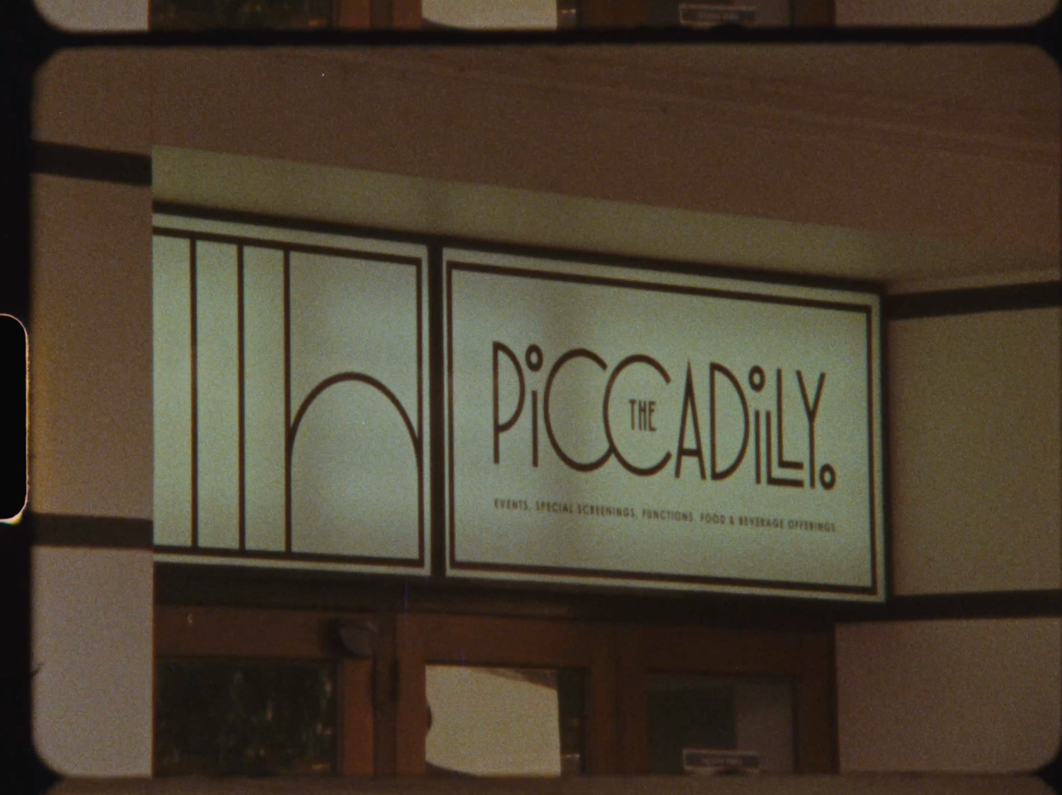 Vintage illuminated sign for The Piccadilly restaurant with Art Deco typography and decorative frame.