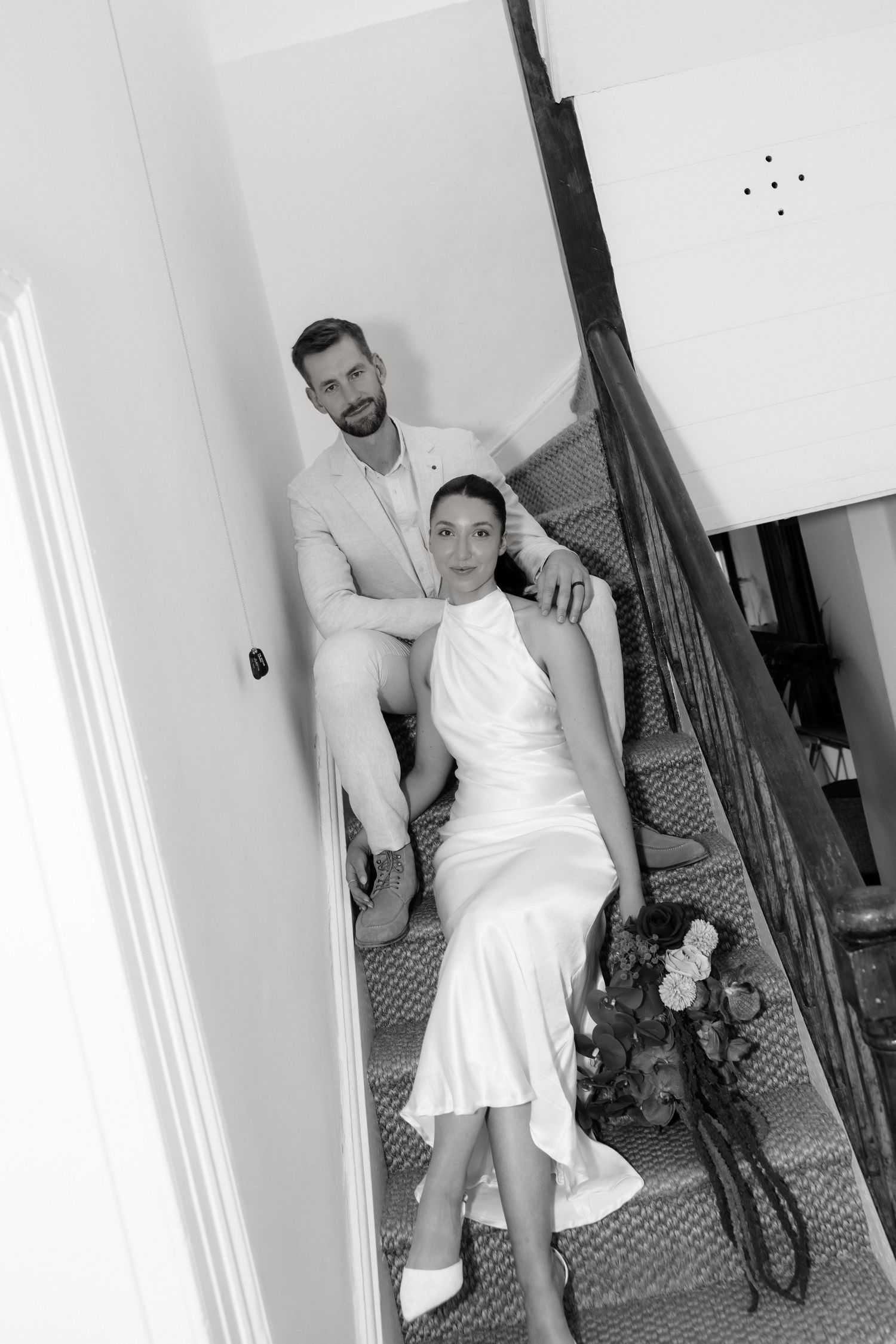 Bride and groom sitting on staircase in black and white wedding portrait at The Station Kapunda.