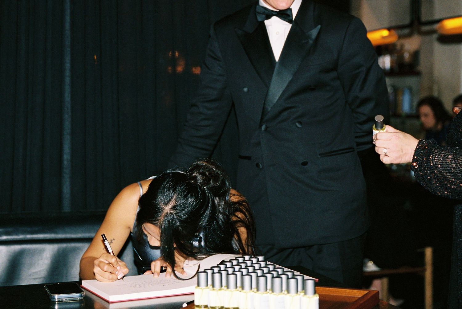 Wedding guest signs the guestbook at a formal evening wedding reception.