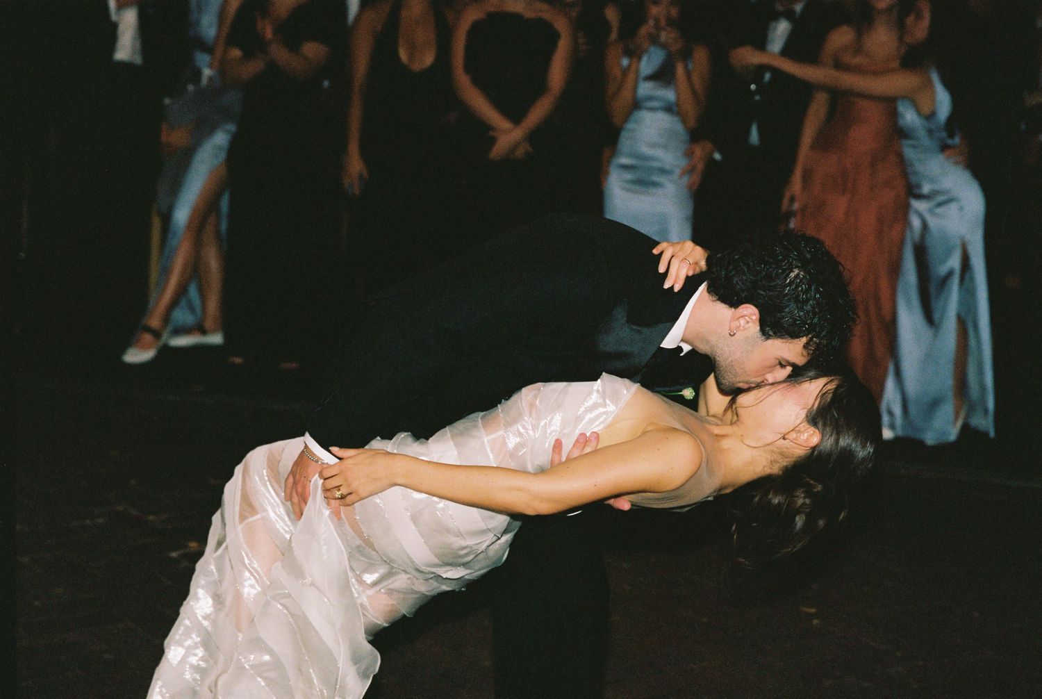 Bride and groom share a romantic dip dance on the wedding reception dance floor.