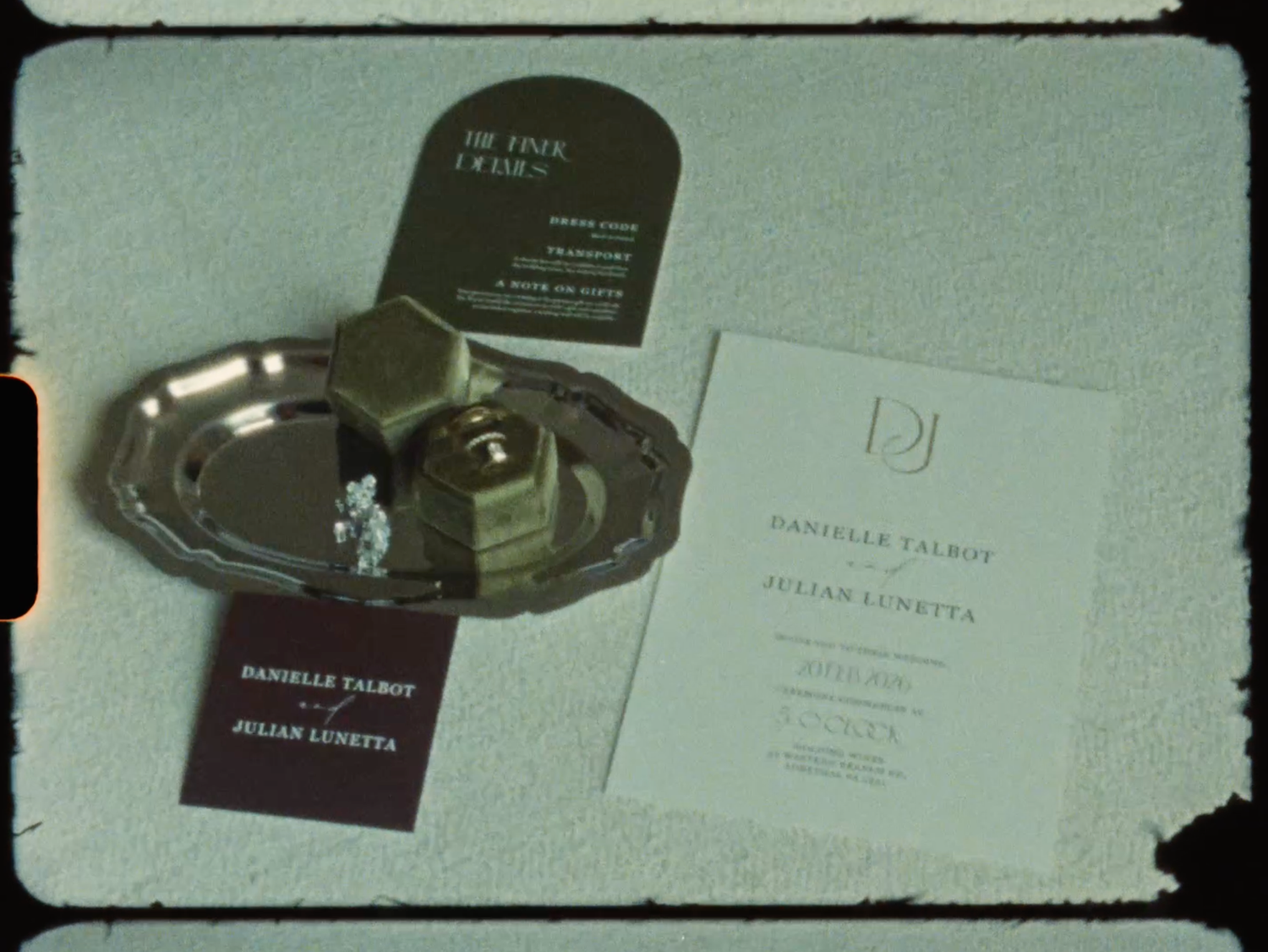 Wedding invitation for Danielle Talbot and Julian Lunetta displayed on a silver tray.