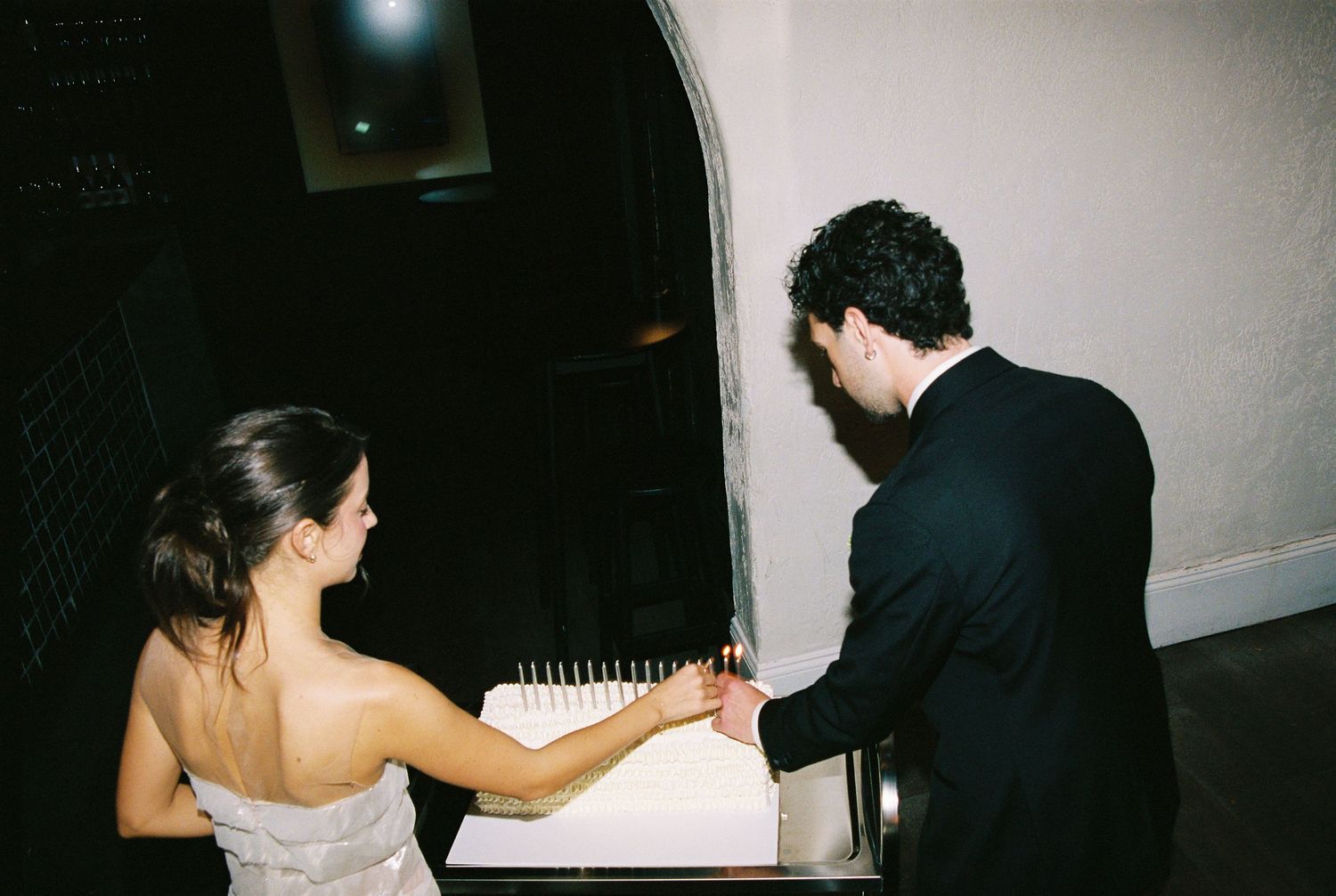 Bride and groom signing wedding guest book together at elegant indoor venue reception.