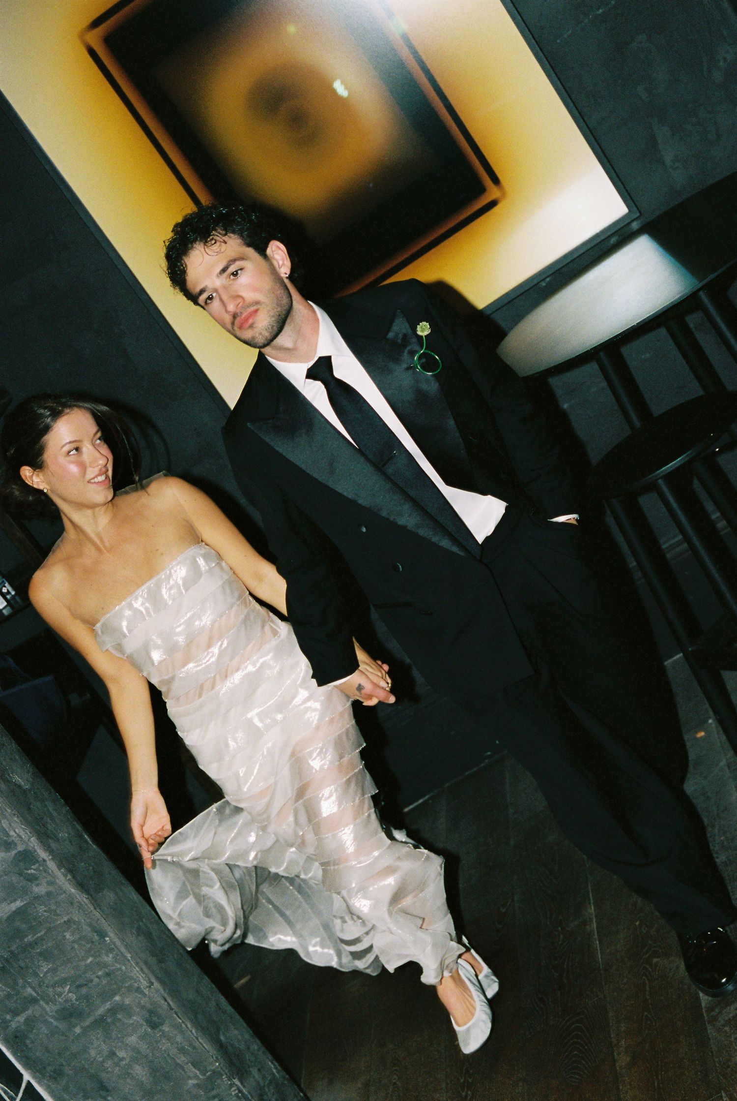 Bride and groom walk hand in hand through their elegant wedding reception venue.