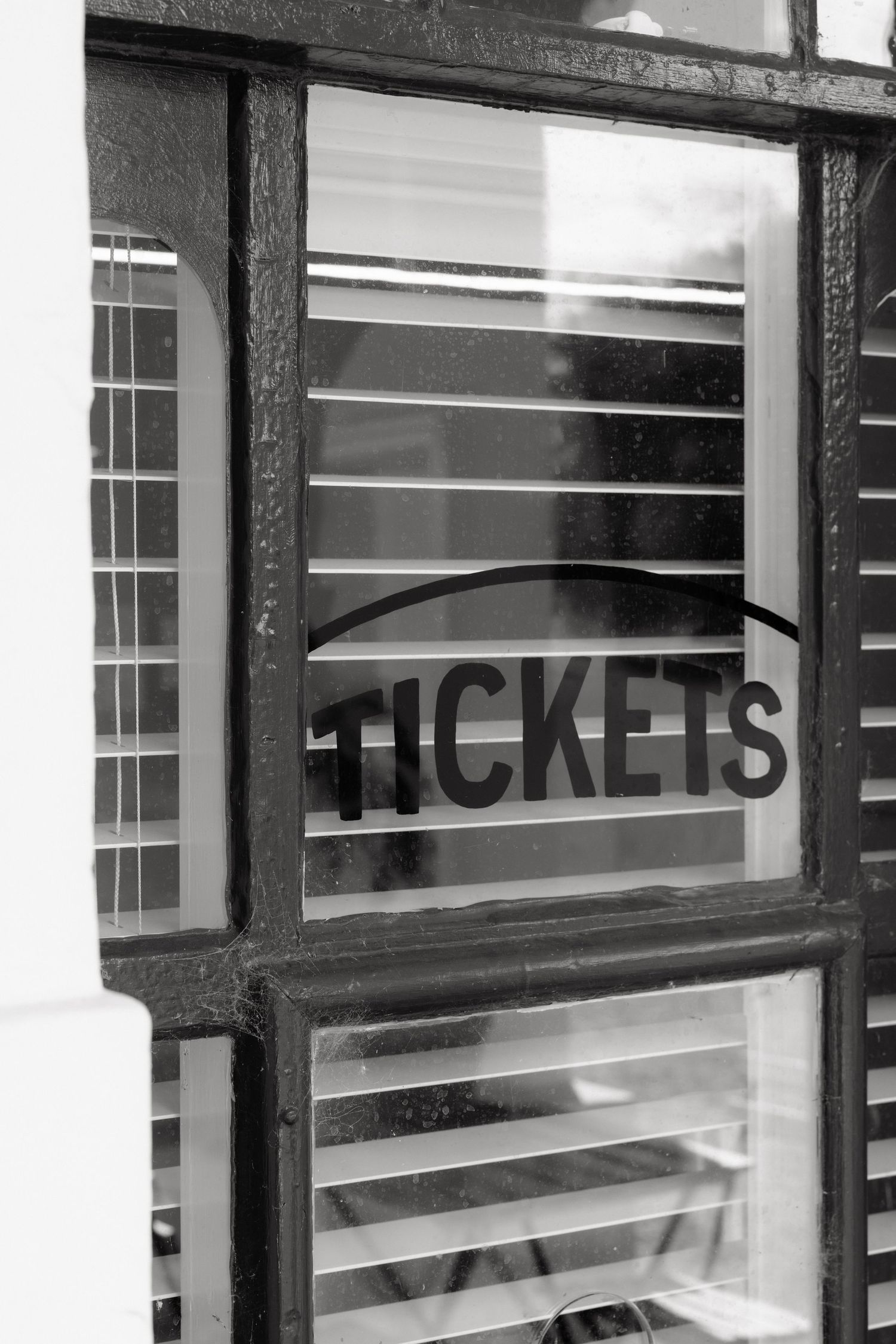 Vintage black and white photo of old tickets window at historic train station wedding venue.