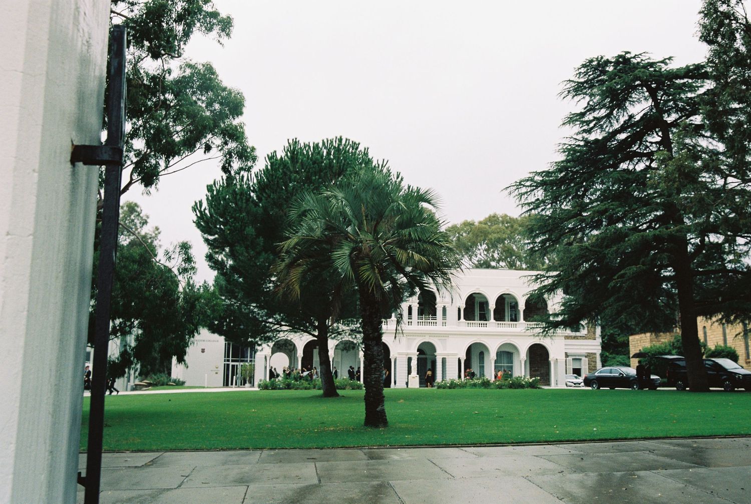 Grand white colonial wedding venue with arched verandas surrounded by lush green lawns.
