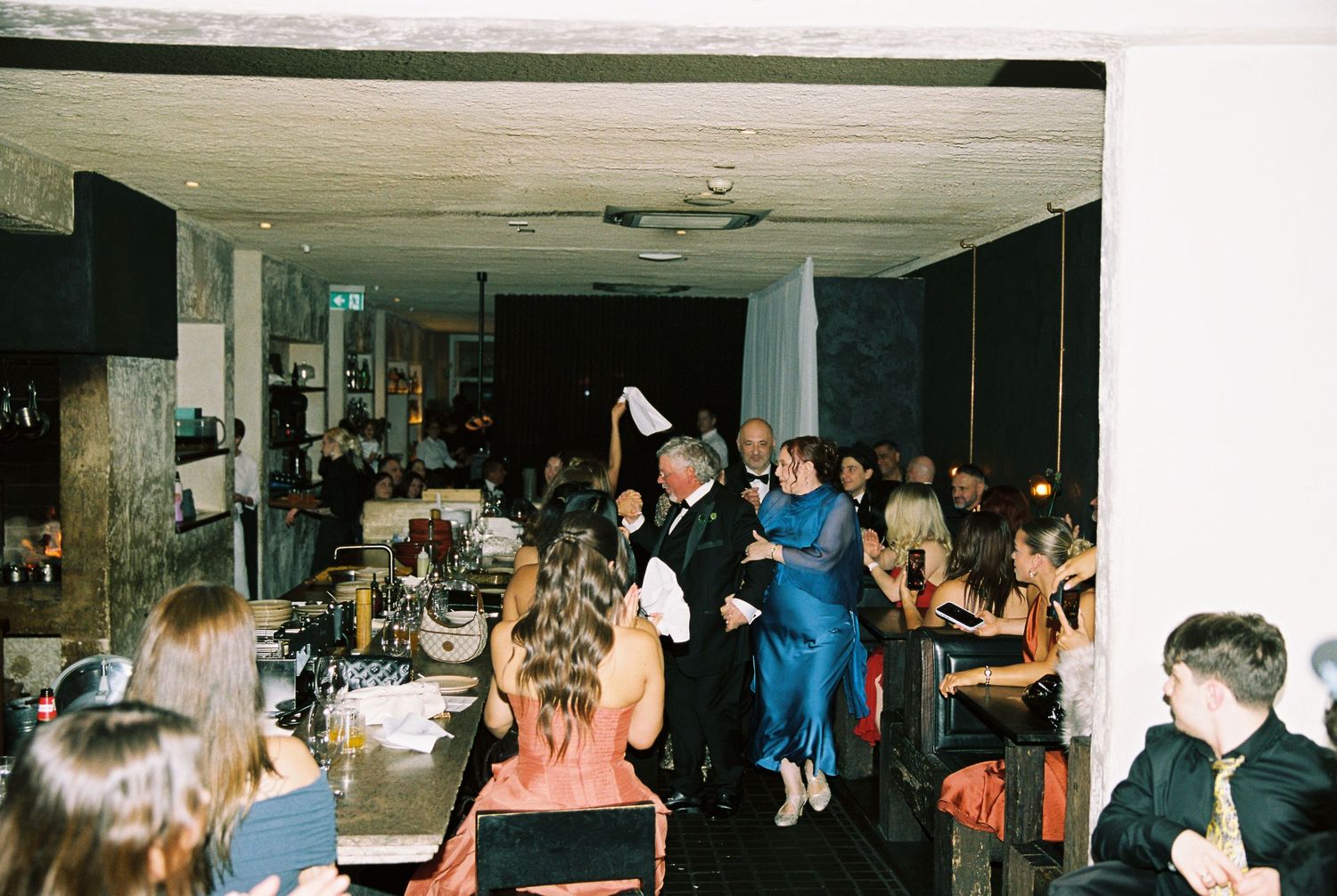 Guests dancing and celebrating at an elegant indoor wedding reception party.