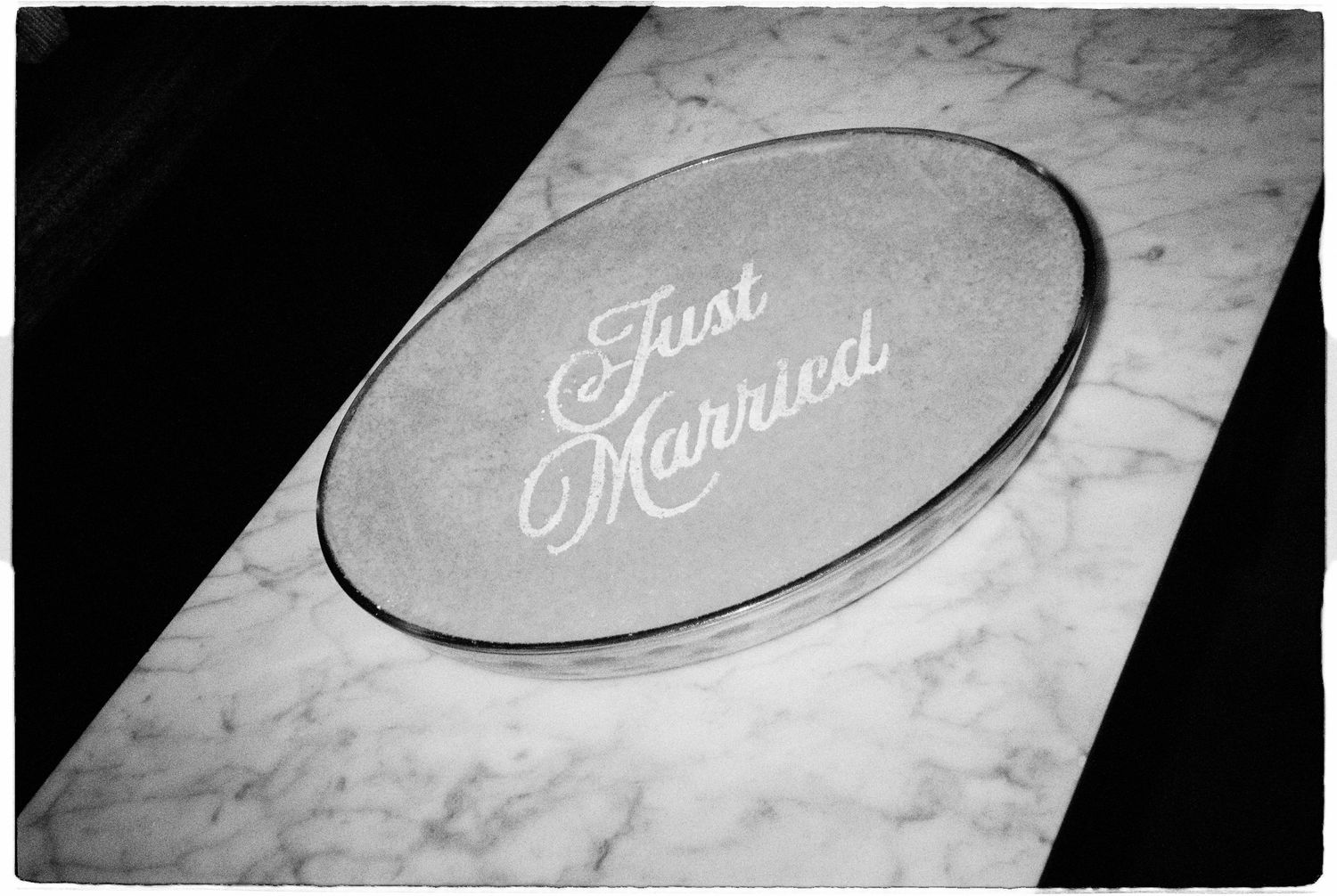 Black and white photo of a marble plaque engraved with Just Married in elegant script lettering.