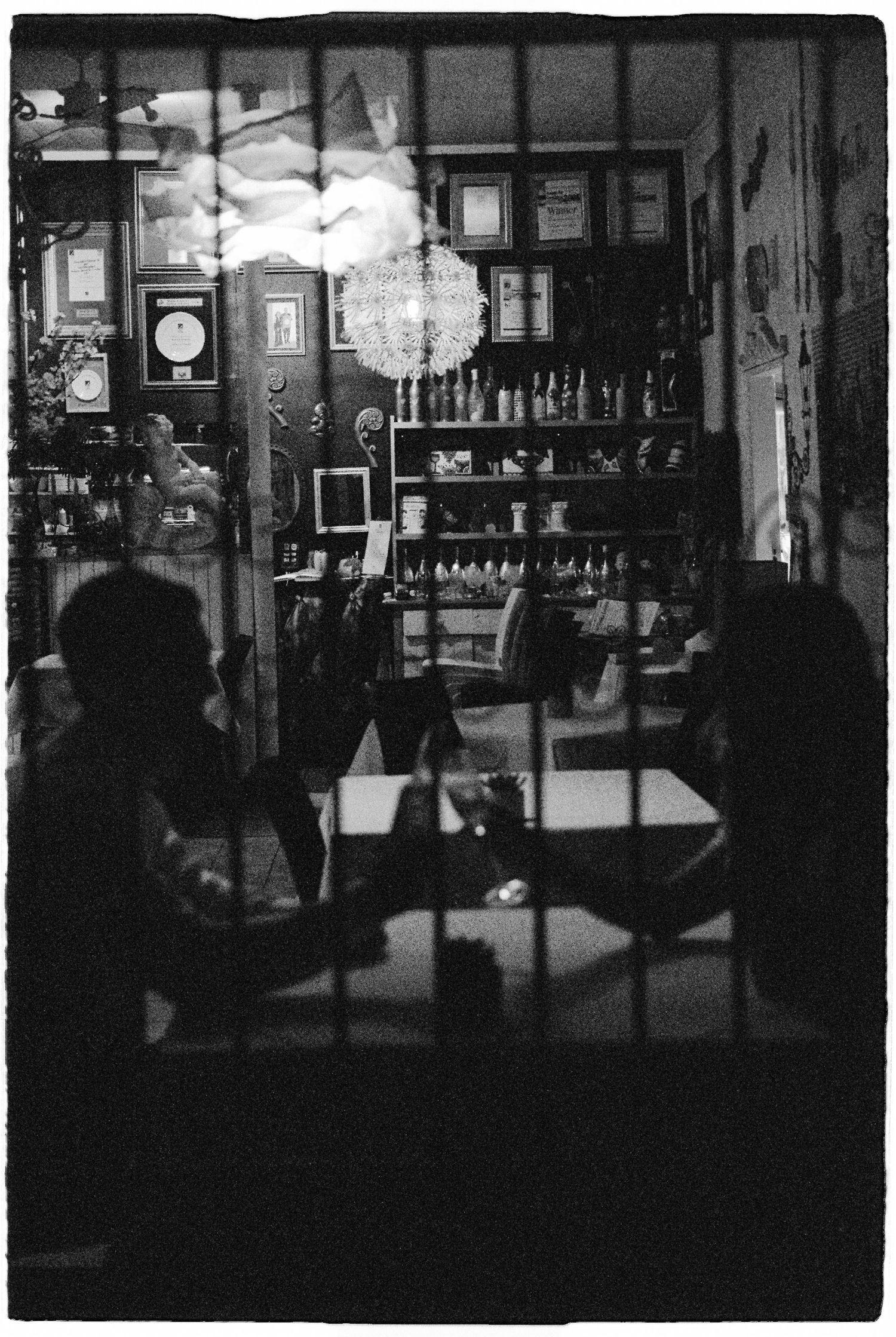 Moody black and white shot of guests inside dimly lit vintage wedding venue.