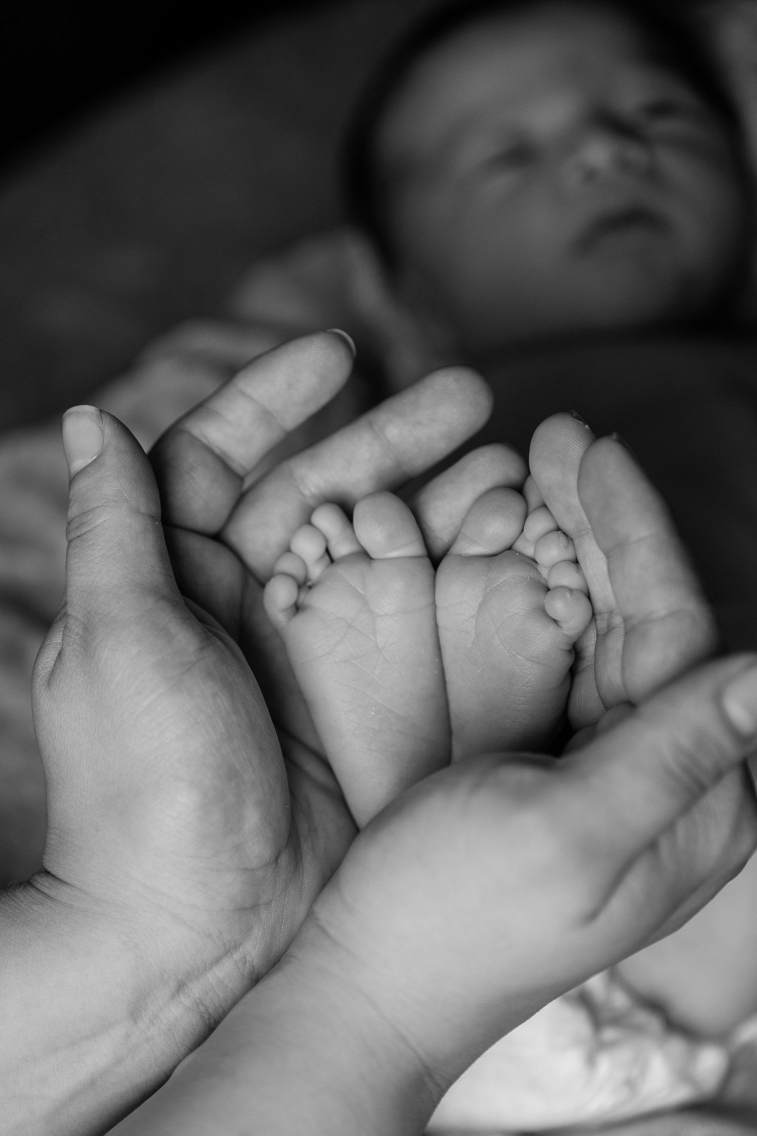 Mother holding her newborn baby's feet