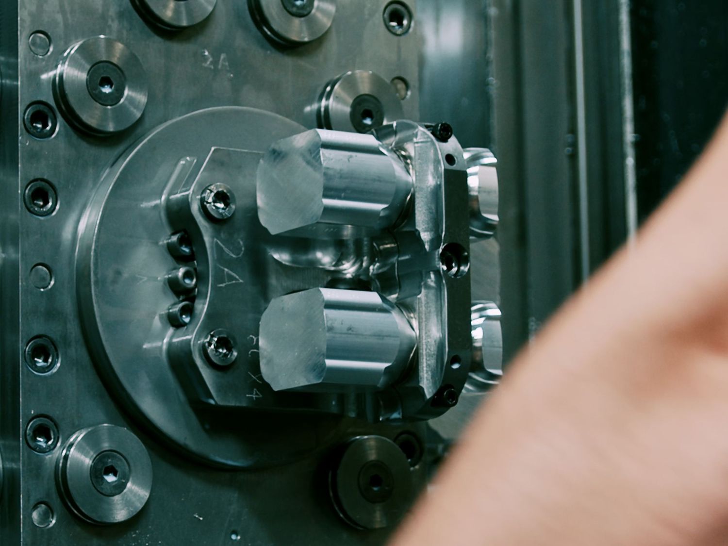 Close-up of a metal lathe chuck holding precision-machined industrial components.