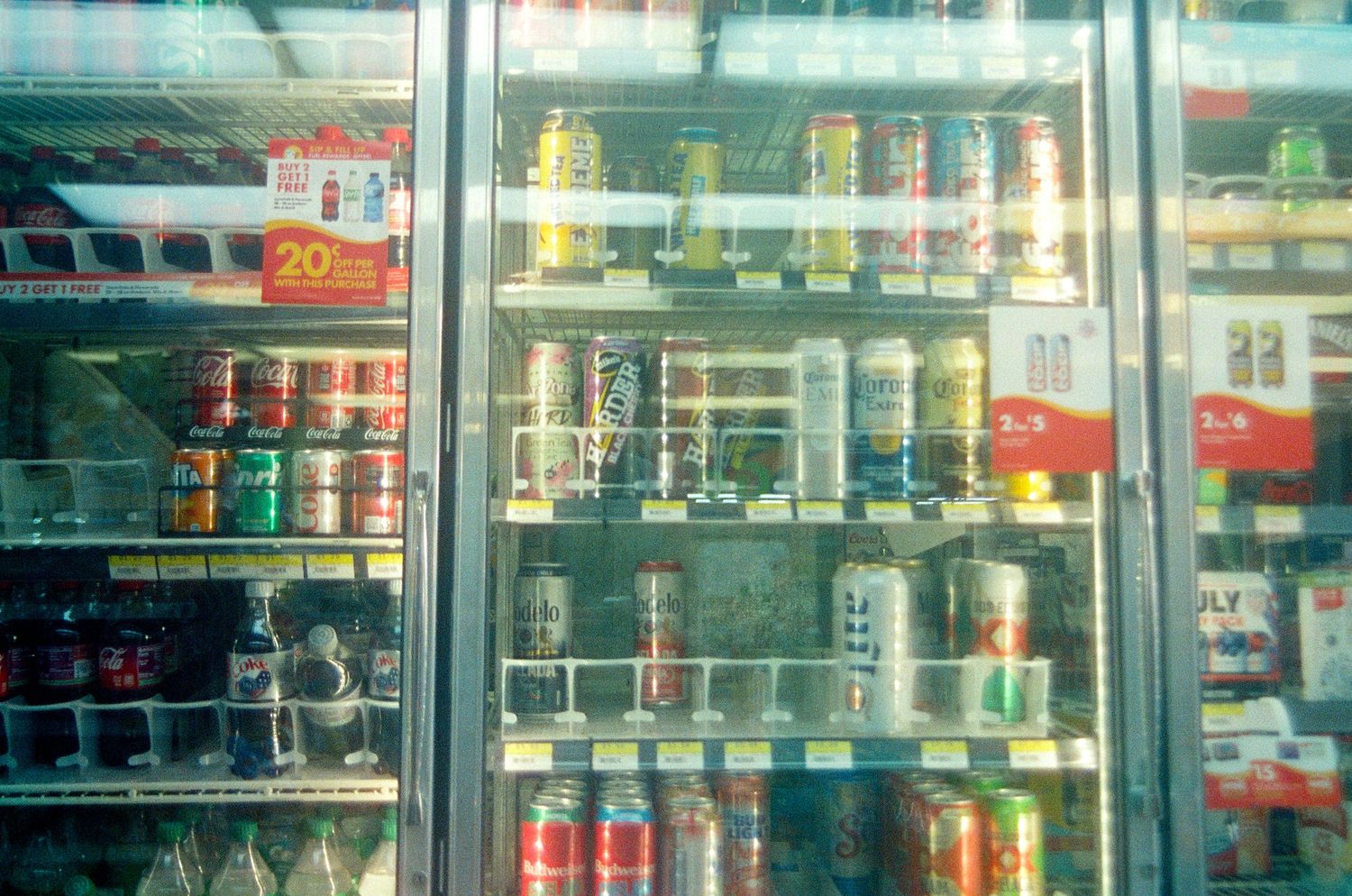 Refrigerated convenience store cooler stocked with assorted canned beverages and energy drinks on multiple shelves.