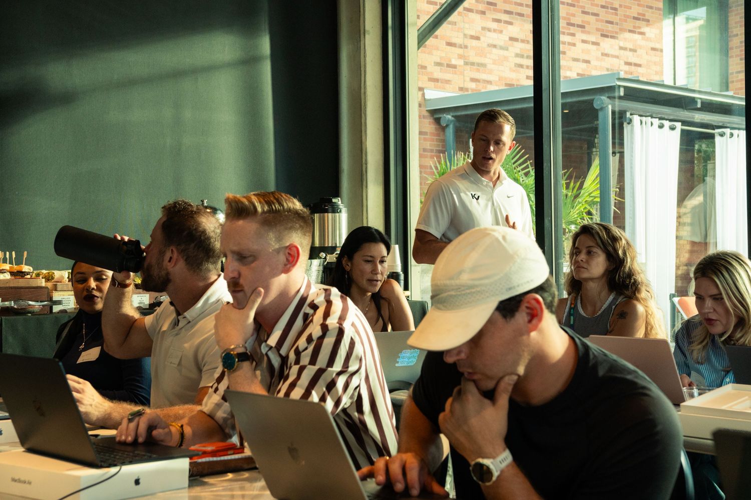 Group of professionals working on laptops in a modern office space during a collaborative workshop session.