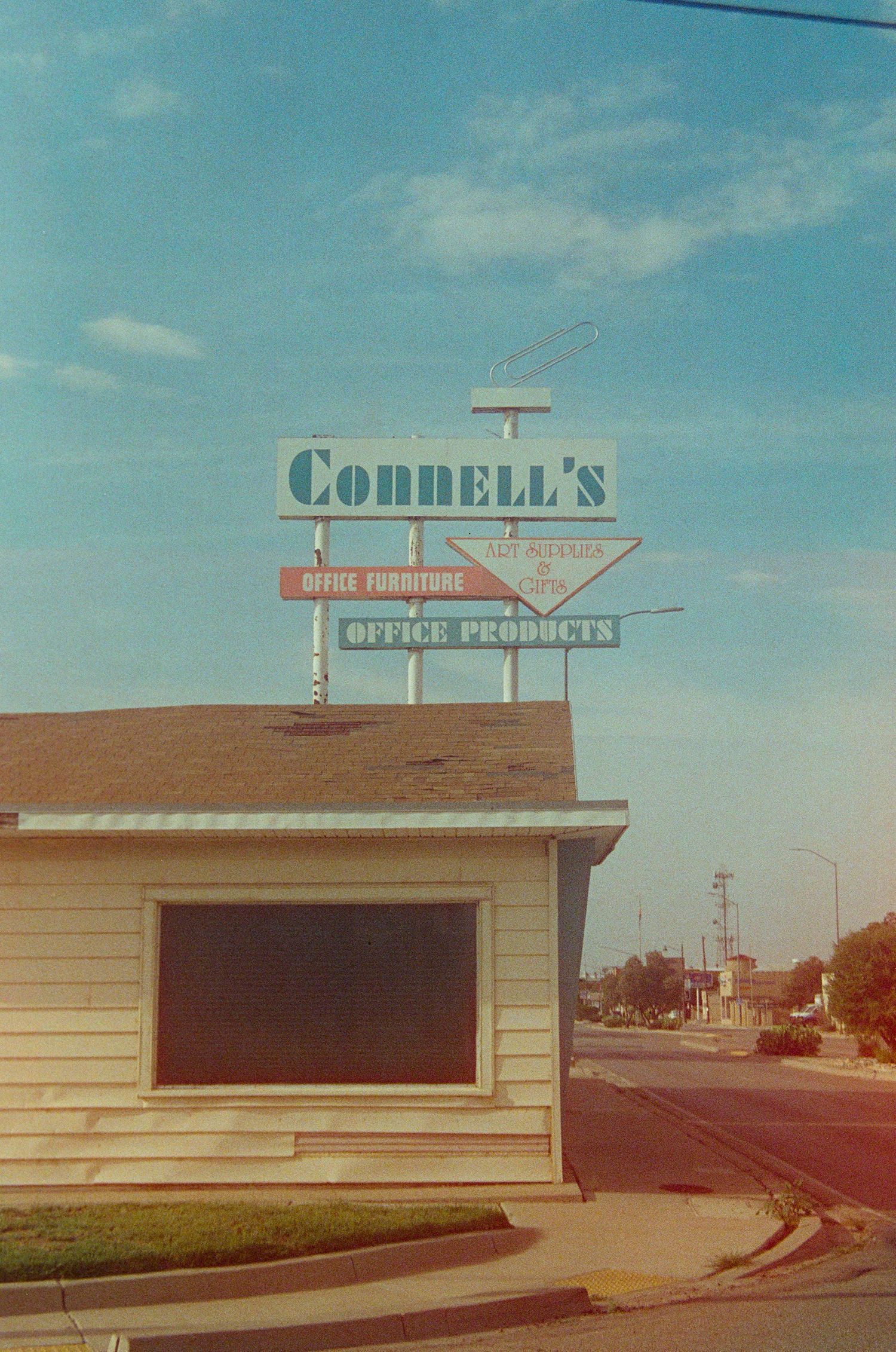 Vintage Connell's Office Furniture and Products sign atop a small building on a quiet street corner.