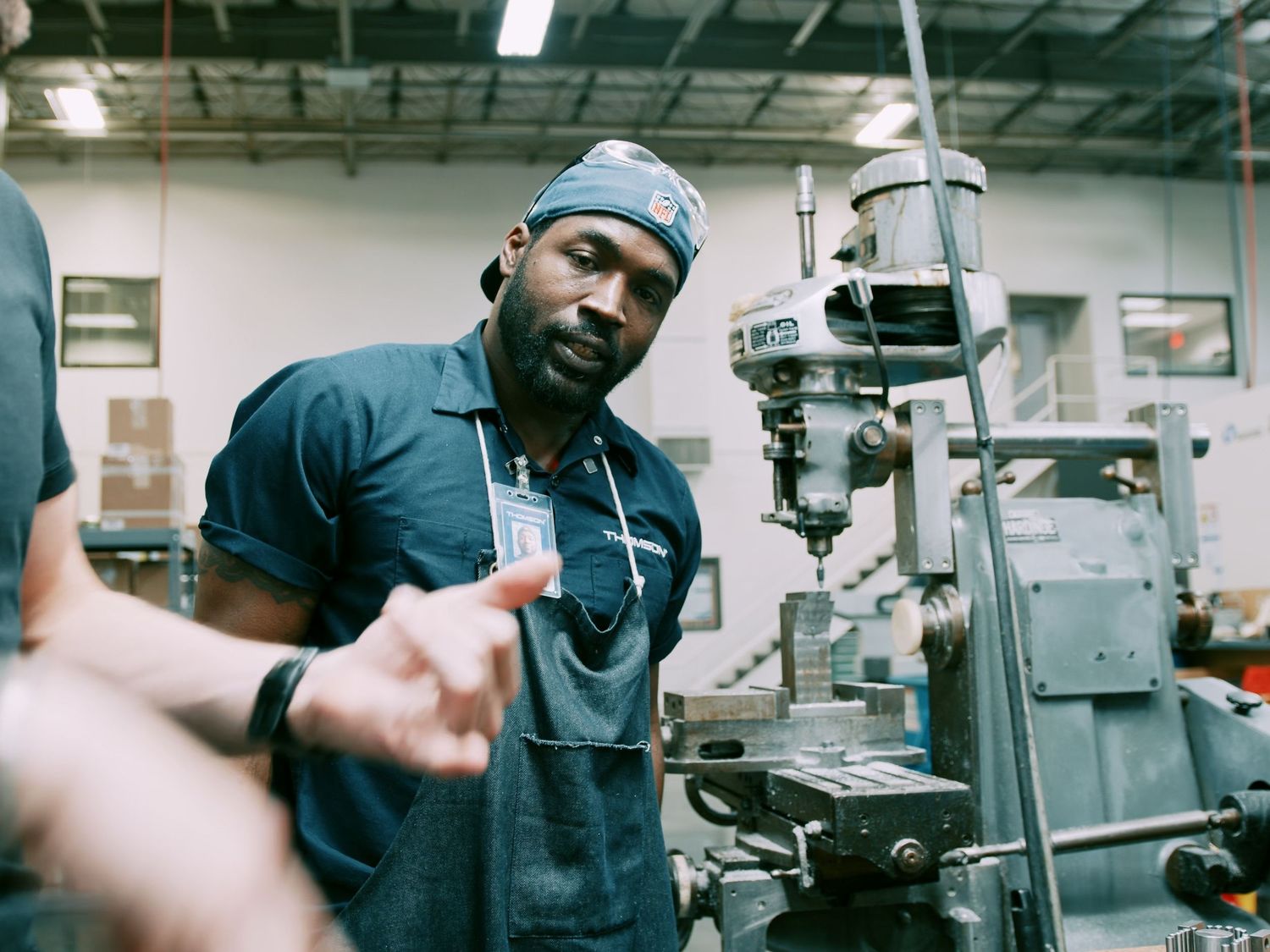 A skilled machinist operates a milling machine in an industrial workshop setting.