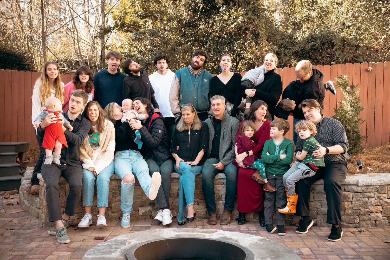 Multigenerational family group photo outdoors in a backyard during winter season.