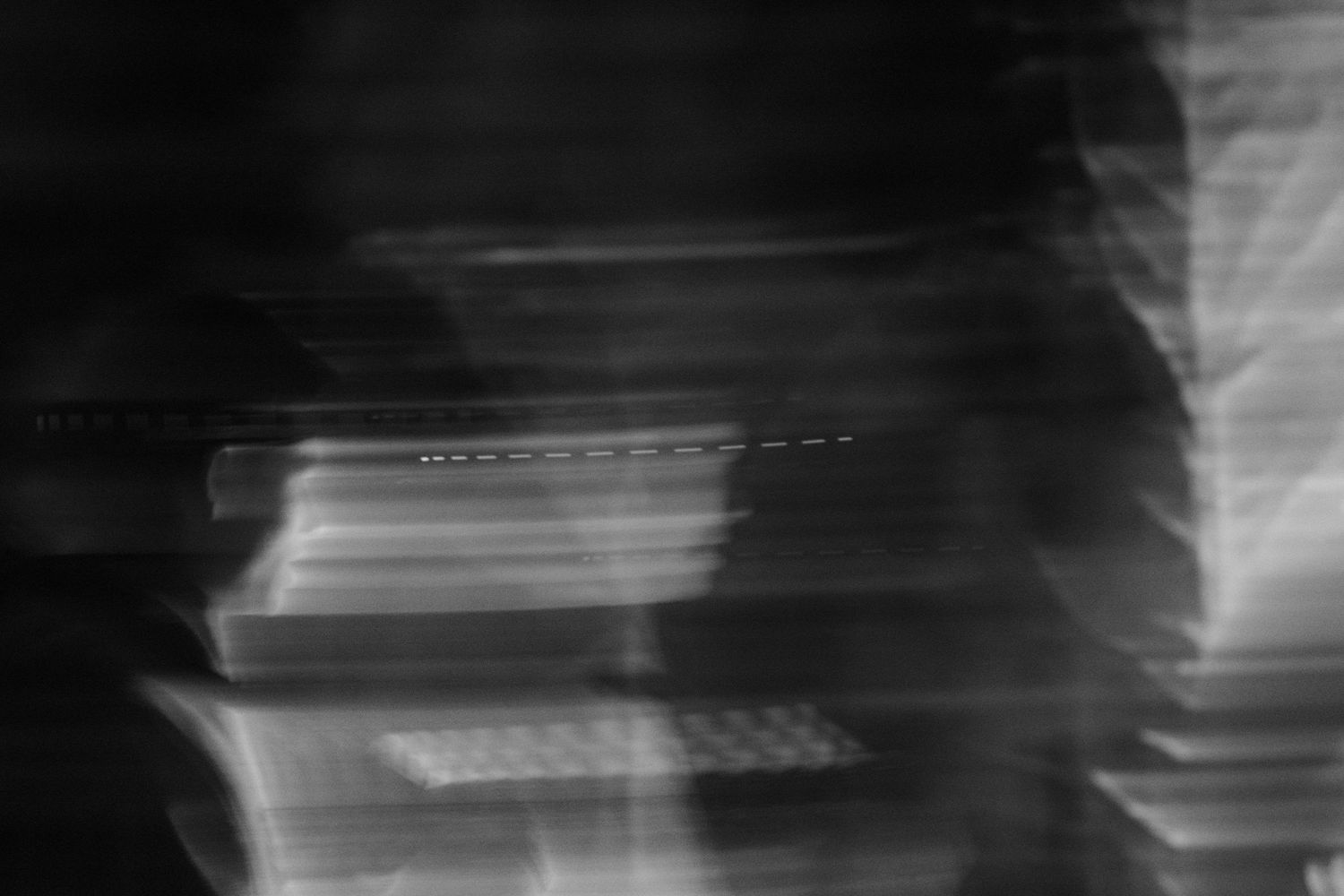 Blurry black and white abstract photo of stacked electronic devices with motion blur effect.