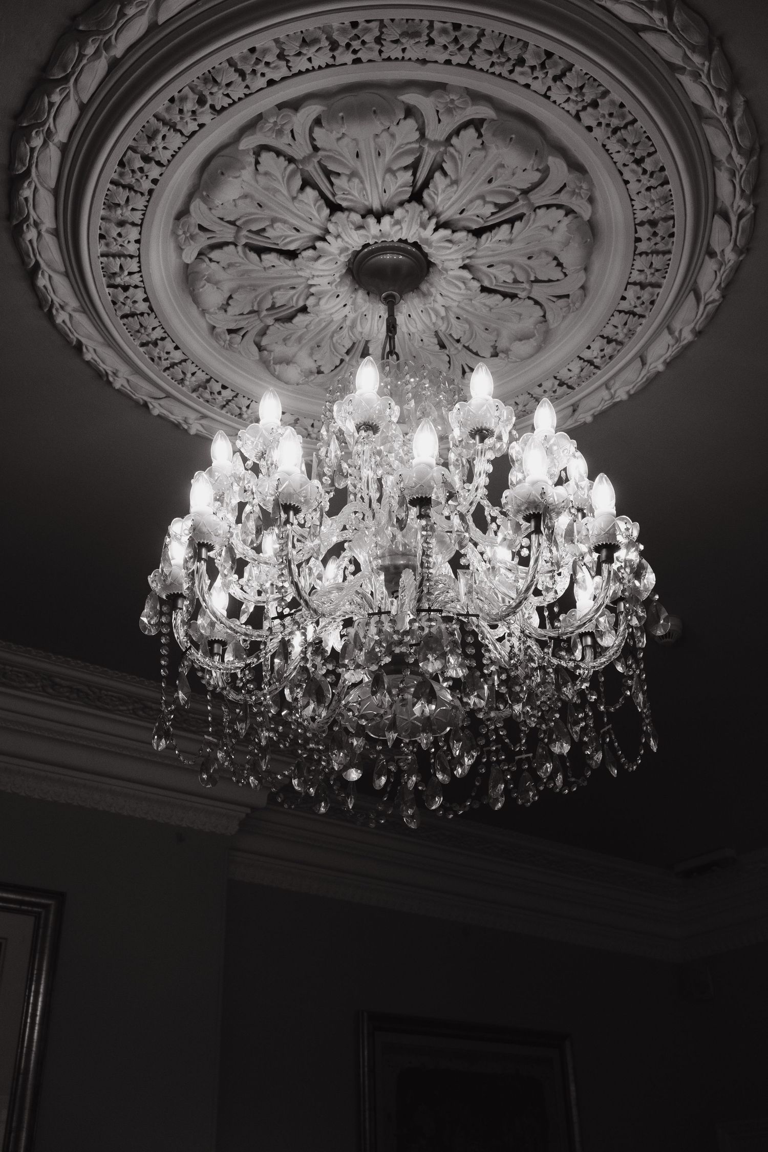 Editorial wedding photography beneath chandelier at Derbyshire wedding venue