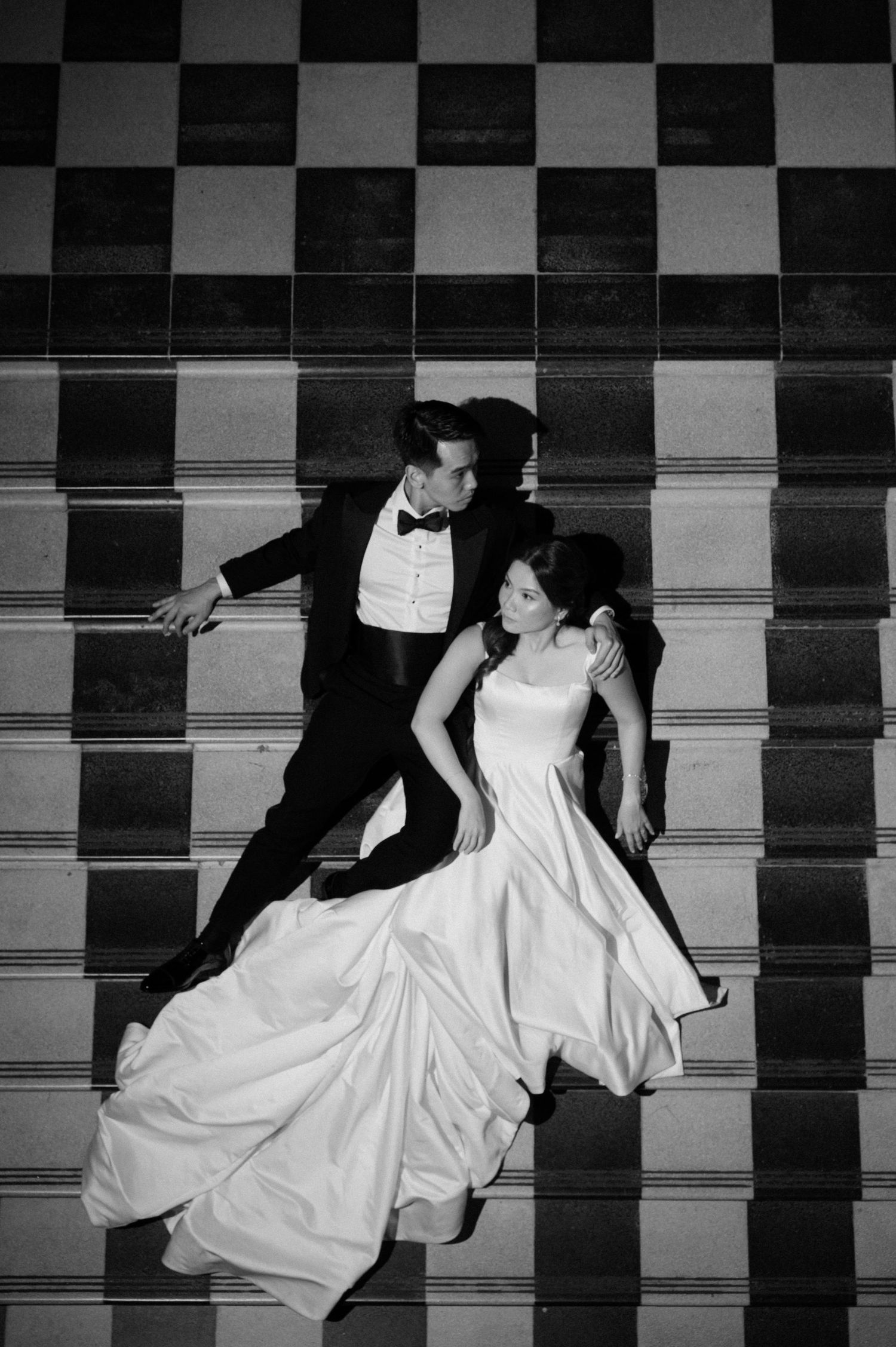 National Gallery Singapore, bride & groom laying on the stairs.