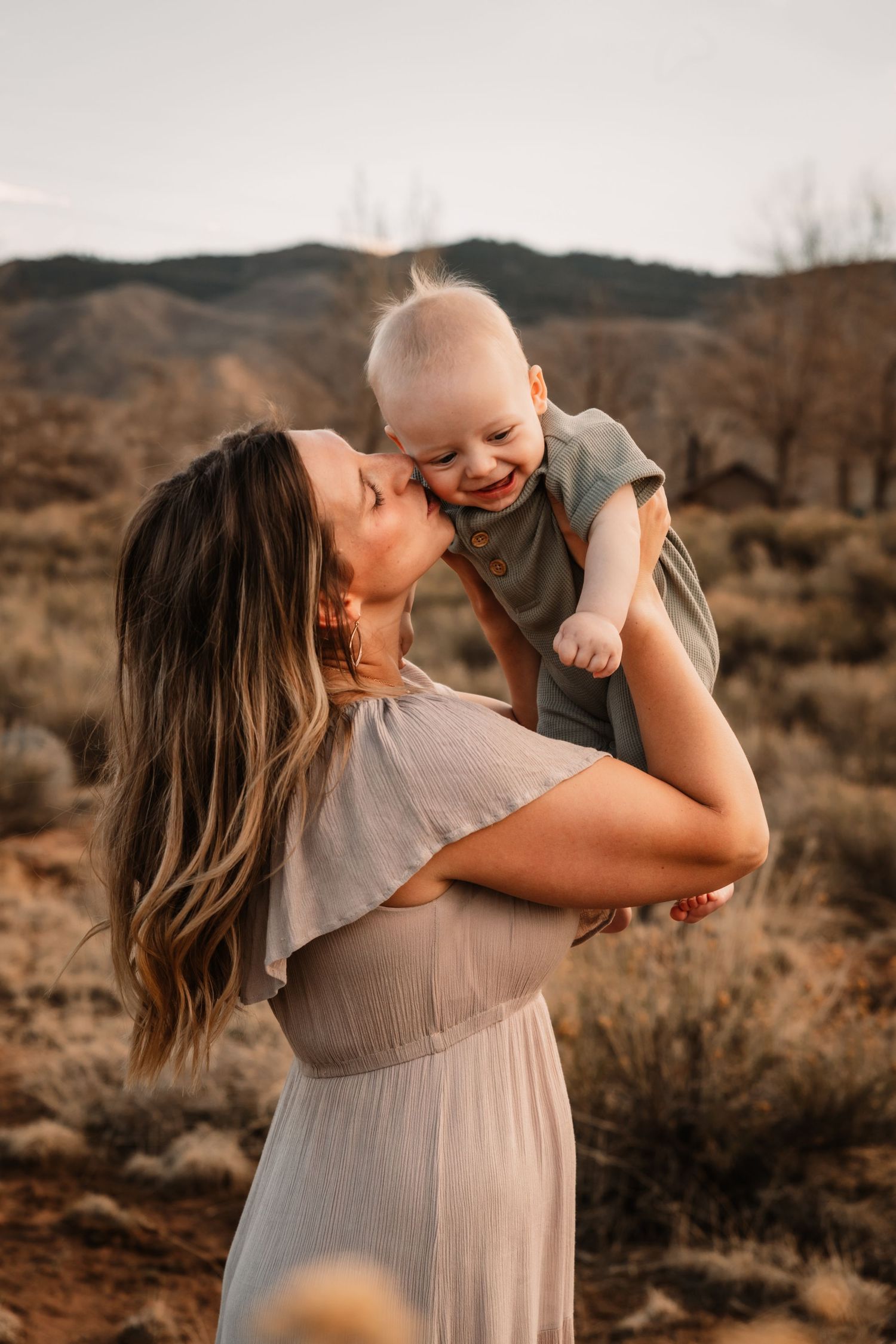 A joyful moment captured at sunset in a desert landscape as they share laughter and embraces.