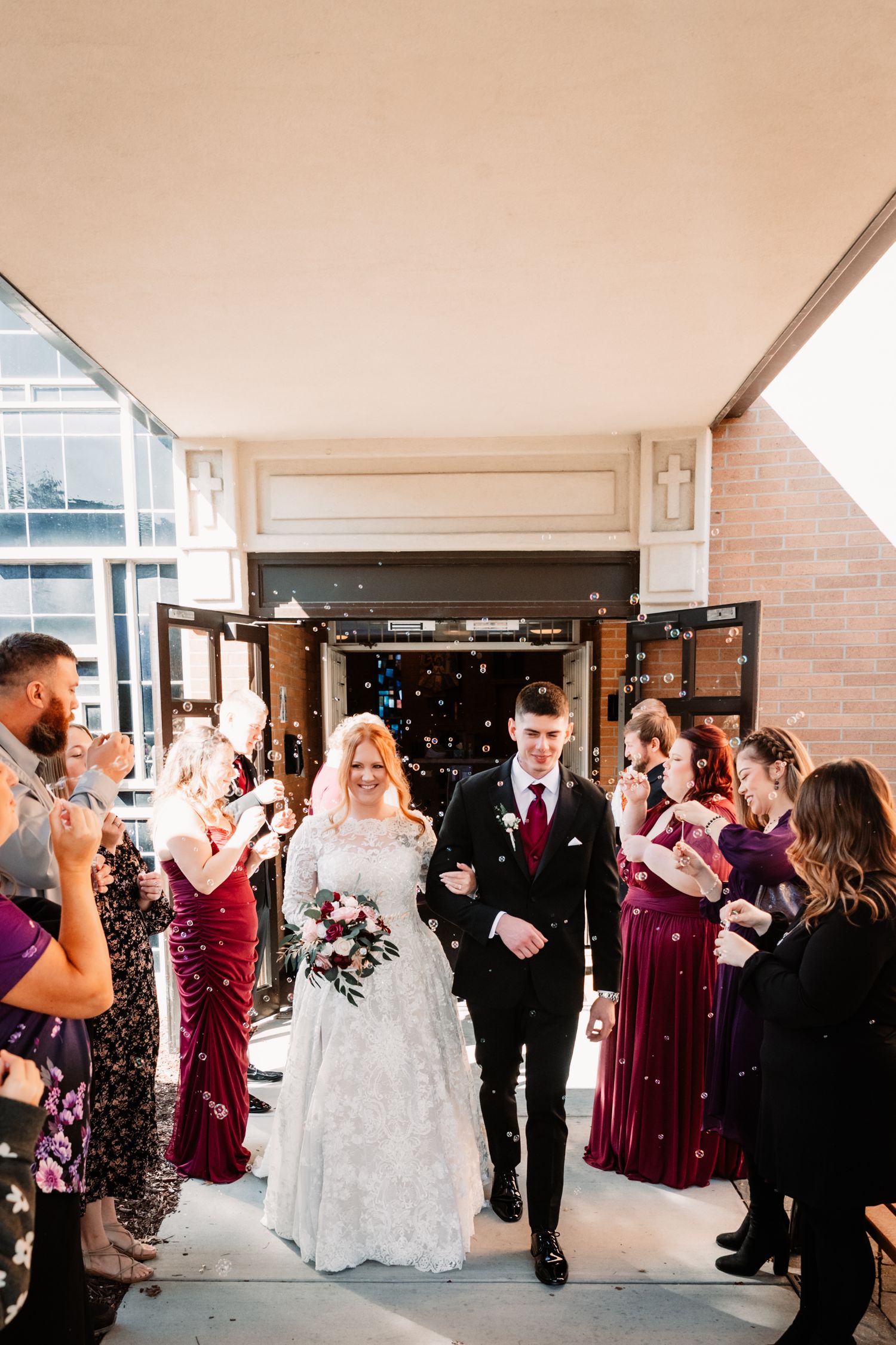 Wedding celebration at venue entrance with guests throwing confetti as newlyweds exit after ceremony.