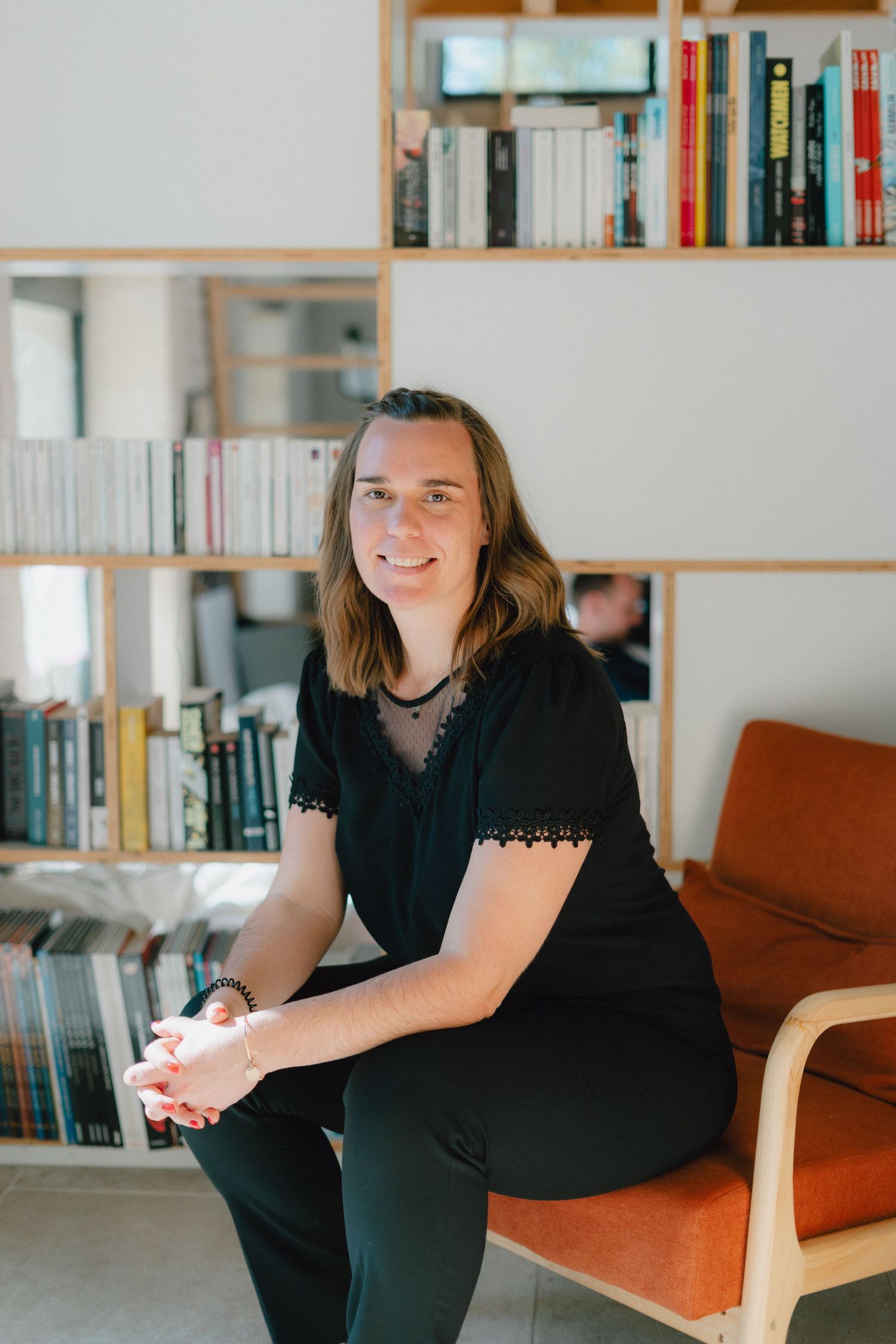 Photo portrait d'une femme entrepreneur avec une bibliothèque en fond.