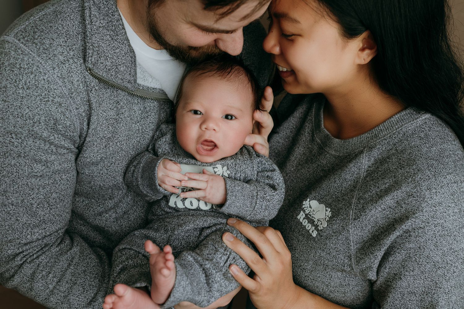A tender black and white photo series showing intimate moments between a parent and newborn baby taking family photo in victoria bc studio.