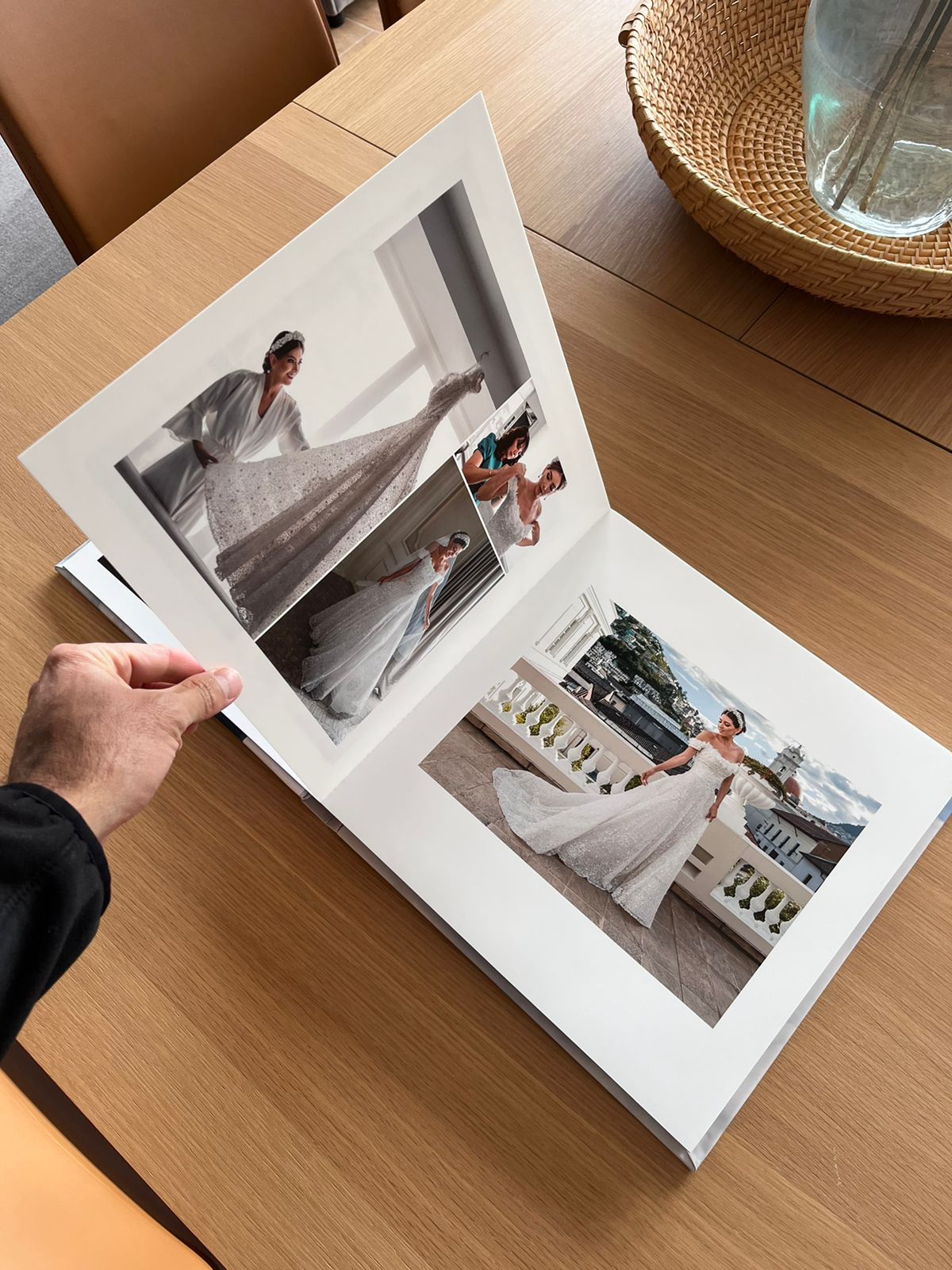 Wedding photo album being viewed on a wooden table with multiple pages displayed.
