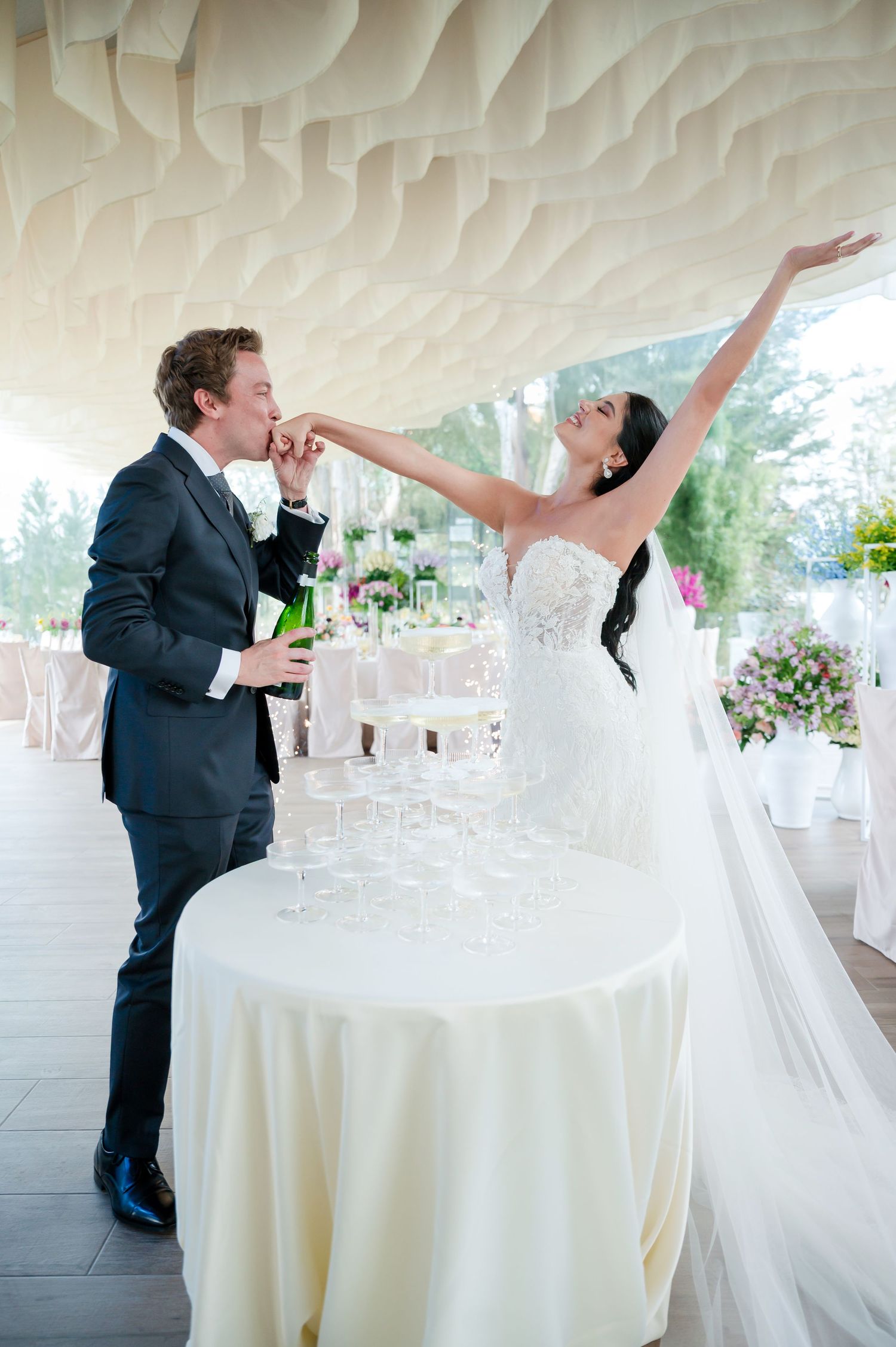 Wedding couple dancing under white textured ceiling in elegant reception venue.