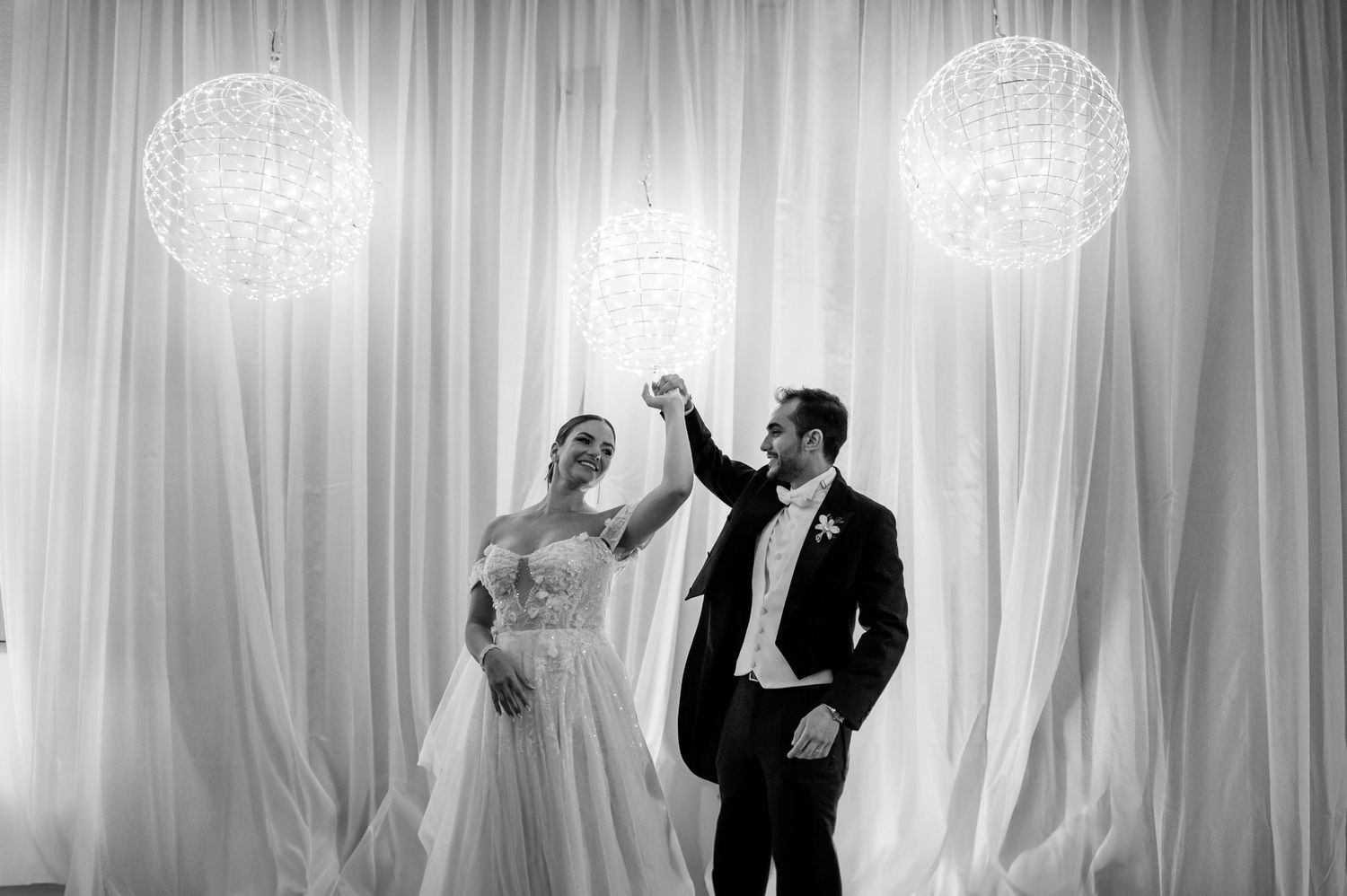 A black and white series of wedding reception photos with elegant crystal chandeliers.