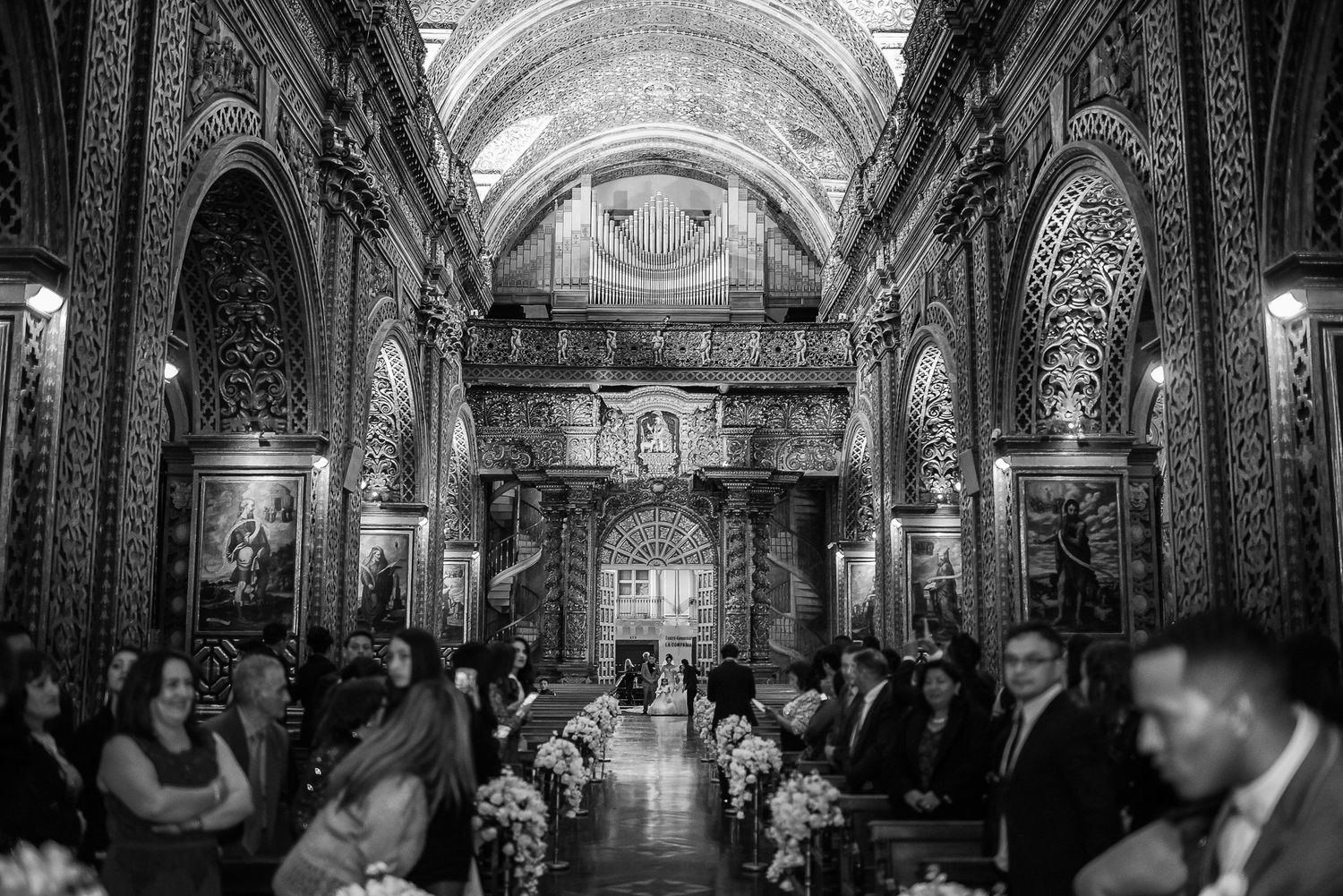 Panoramic view of ornate church interior with vaulted ceilings and detailed architecture.