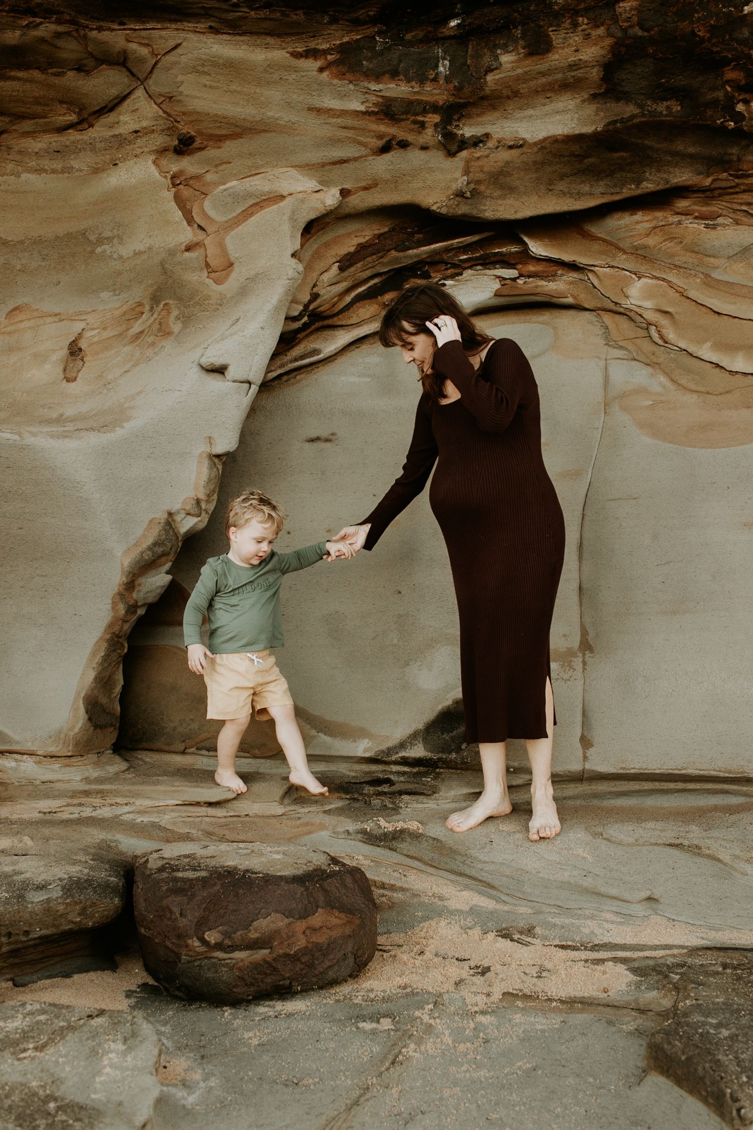 mother and sun exploring rocks at Sunshine Coast beach