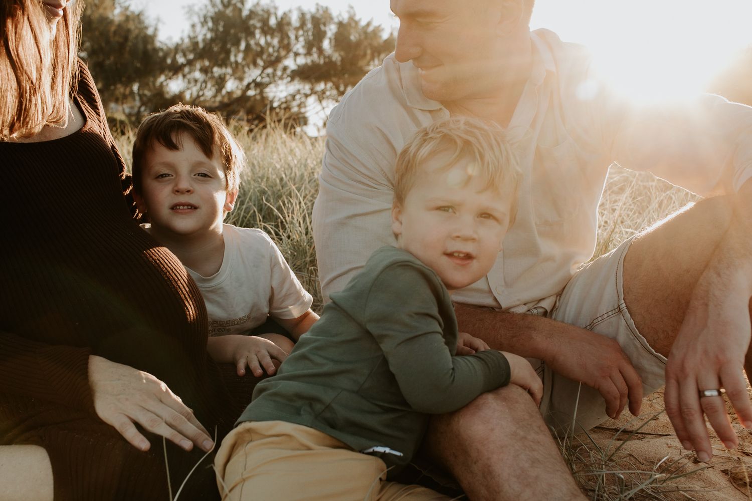 mum, dad and two sons basked in golden light in sunset family photo session Sunshine Coast