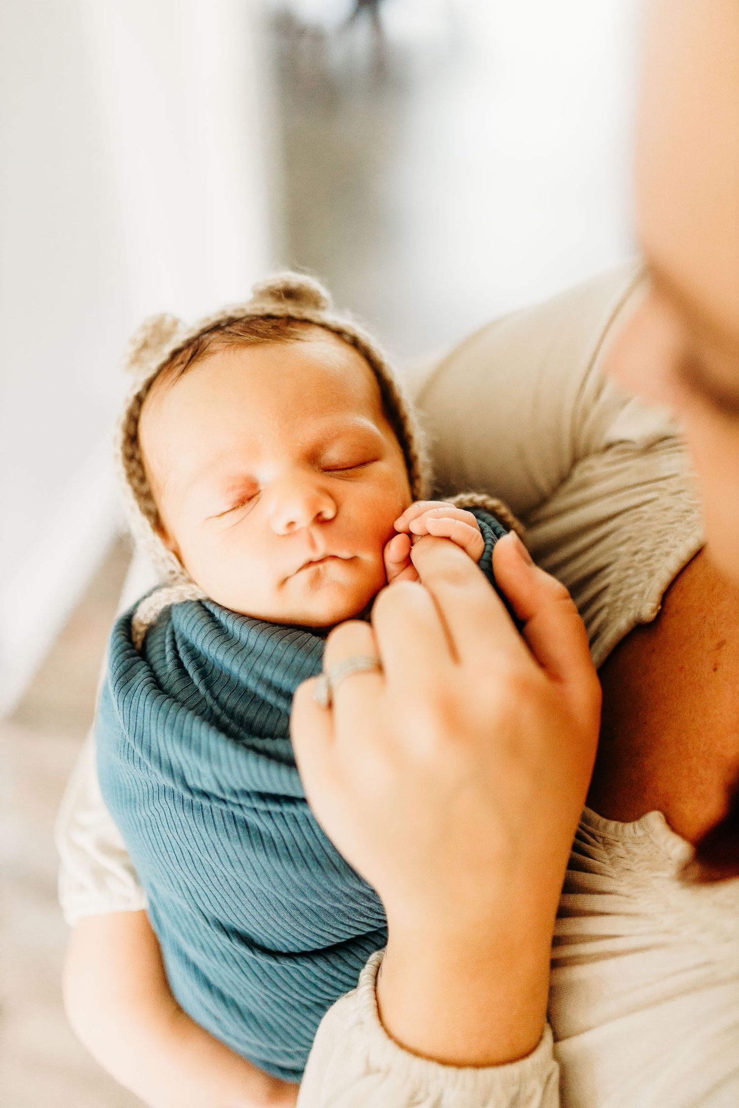 a mother holds the little hand of her newborn baby boy