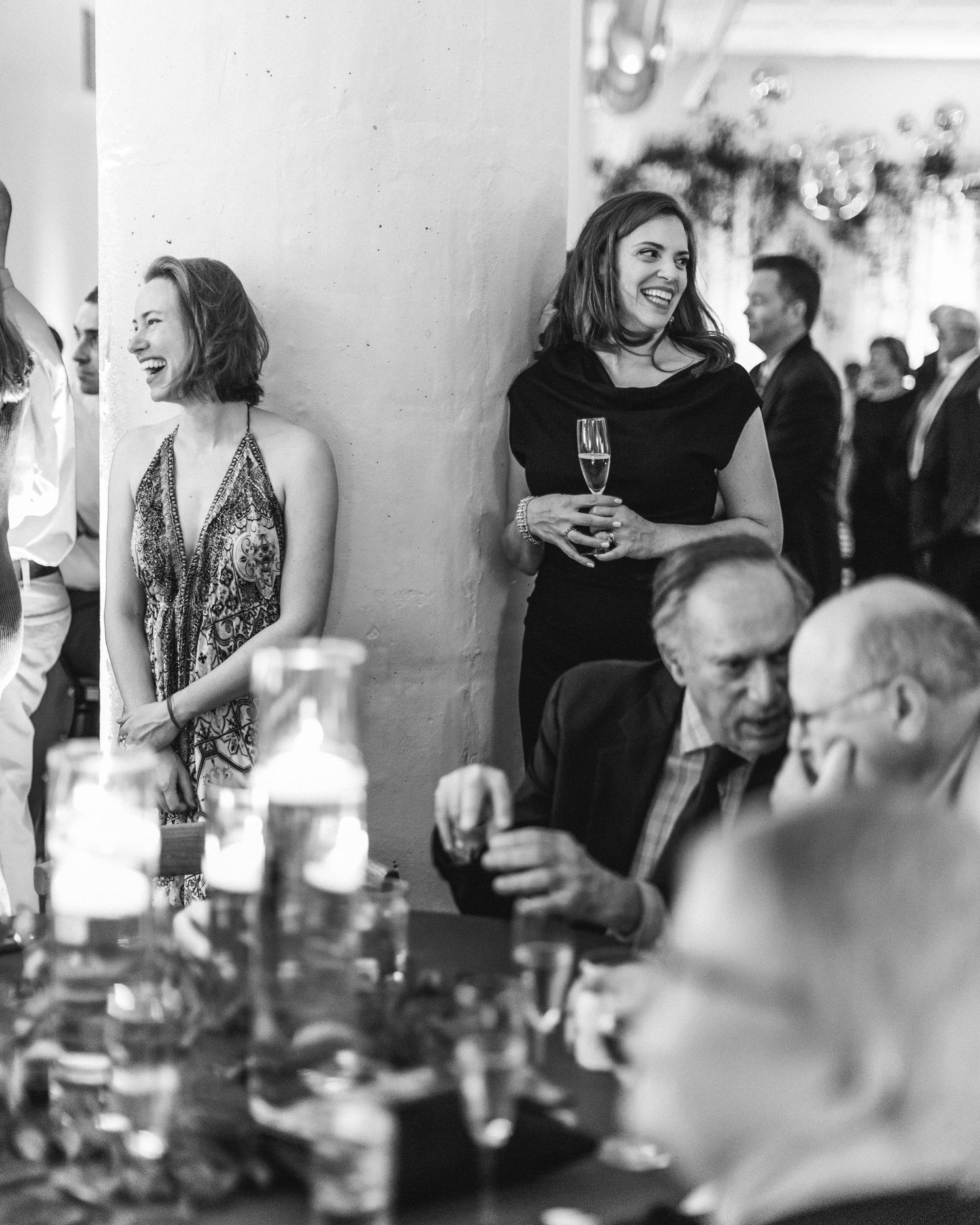 Lively wedding reception scene with guests mingling and enjoying drinks at decorated venue.